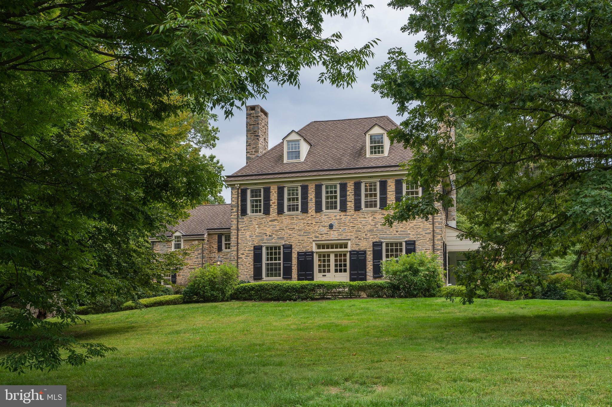 Welcome to 38 Summit, one of the most spectacular properties in Chestnut Hill. Originally built
in 1857 as a Victorian, this house was completely transformed into a Colonial Revival dwelling
by the famous architect Broknard Oakie in 1919. The spectacular attention to detail from this
period includes custom millwork, random width floors, iron hardware, multiple fireplaces, high
ceilings and French doors throughout. The property is sited on two acres on historic Summit
Street, one of the highest points in Philadelphia, with the main house set back from the street by
a sweeping front lawn and a separate carriage house behind. The current owners have
meticulously maintained and improved the property to the fine standards to which it deserves.
One enters the main home through double doors with transom windows and a stone floor to a
lovely entrance hall that is accessed by all adjacent rooms. Filled with light, this large hall makes
for a wonderful welcome and allows for comfortable entertaining throughout the first floor. The
entrance hall is flanked to the left by a cozy den perfect for an office and to the right by the living
room with large fireplace, floor to ceiling bookcases and three sets of French doors that lead to
both a back flagstone patio and a side covered porch. The dining room with fireplace and three
sets of additional French doors, and coat room and powder room under the grand staircase
complete the formal living space.
The wing to the left of the entrance hall and dining room includes a magnificent chef’s kitchen,
breakfast room and bar area that opens to a comfortable family room, powder room and mud
room. The kitchen includes custom cabinetry, thick honed marble counters, professional
appliances including a Wolf 6 burner range and Sub-Zero refrigerator, farmhouse sink, large
center island with seating for five and a glass wall of windows and French doors that open to
the back flagstone patio. The breakfast room includes a seating area with built in seating and
storage, pantry area and a bar area with wine refrigerator. The kitchen opens to the family room
and back mud room with built in desk, hearth and stone floor.
The second floor is accessed by the wide staircase in the main entrance hall with hall landing.
The primary bedroom suite includes a large bedroom with fireplace and sitting area, two walk-in
closets and a main bathroom with two vanity sinks, walk in shower and separate jacuzzi tub.
This floor also includes a second and third bedroom both with adjoining baths, laundry room,
hall bath and two more rooms that could be used as offices or bedrooms. The third floor
includes two additional bedrooms and a hall bath with original marble sink. There is tremendous
storage and closet space throughout.
The charming two story carriage house includes three bedrooms, updated kitchen and full bath,
dining room and large living room with a private flagstone patio. The carriage house includes a
two bay heated garage and there is a separate custom built shed with workbench and separate garbage compartment.
The private grounds include many mature trees and plantings and multiple patios and covered porches to enjoy the property. All this is just a short walk to the many shops and restaurants in Chestnut Hill, the
trails of Fairmount Park and regional rail service for an easy commute to Center City.