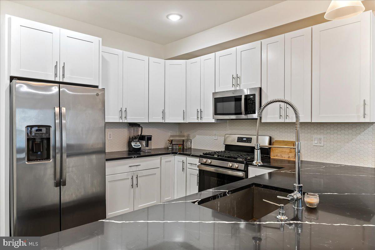 WELCOME TO WEST MONTGOMERY!
This fantastic 2 bedroom 2 bathroom condo has 11ft high ceilings, private entrance and parking available. Upon entering the front door you're immersed into a spacious living area with large front windows, dark oak hardwood flooring and a stunning black and white kitchen! The L-shaped Kitchen accommodates counter top seating, includes high-end stainless steel appliances, black and white quartz counter top, a trendy back splash, modern light fixtures and custom cabinetry! The perfect space to cook up any meal! Head down to the lower level that includes a Laundry Closet, Storage Closet, Guest Bedroom, Guest Bathroom, Primary Bedroom, Primary Bathroom and Linen Closet. Both bathrooms are tiled from floor to ceiling. This home is equipped with smart home technology which includes an intercom. Full sized washer/dryer also included! Conveniently located near major transportation, walking distance to plenty of restaurants, supermarkets, and Temple University. Easily accessible to Broad St, I-676, and I-95.