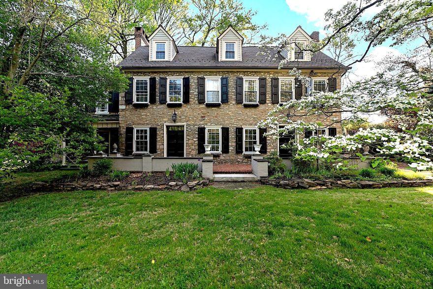 Welcome to a stately 1780 legacy estate that seamlessly marries the prestige of a former Quaker meeting house with a quarter-million dollars in comprehensive modernization. Situated on a rare 1.22-acre lot in the heart of historic Langhorne Borough, this residence is set back over 200 feet from the street, offering a commanding presence and a level of privacy virtually unmatched in the area. The expansive front lawn is protected by a conservation easement, guaranteeing that your sweeping views and lush greenery buffer remain undisturbed in perpetuity. A grand circular carriage drive leads to an inviting front brick patio and masonry sitting wall, where a massive 8-foot-tall custom wood door opens into an interior defined by soaring 10-foot beamed ceilings and recently refinished Brazilian cherry floors.

The architectural integrity is preserved in its 18-inch thick masonry walls and deep-sill windows, yet the living experience is thoroughly modern. The home features a grand Reception Hall with a floor-to-ceiling artisan reading nook, fireplace, and library, which connects via 8-foot converging pocket doors to a formal Parlor. When opened, these spaces transform into a magnificent Grand Double Parlor, offering a uniquely flexible floor plan for large-scale entertaining or secluded relaxation. The chef’s kitchen serves as the heart of the home, boasting coffered ceilings, granite counters, a signature copper main sink complemented by a secondary prep sink, and intricate custom cabinetry.

This landmark property stands as a testament to continuous stewardship, with approximately $259,000 in documented capital investments. The mechanical and structural core was transformed by an extensive overhaul including a whole-house PEX-plumbed hydronic (Modern Radiator) heating system, structural reinforcements, and premium insulation. This foundation is complemented by a recent surge of upgrades: high-velocity central air (2023), a newly added designer first-floor powder room (2026), and a stunning second-floor bath renovation (2026) featuring a custom walk-in tile shower with glass doors. An additional second-floor bathroom offers the year-round comfort of existing radiant heated floors. Peace of mind is anchored by a $19,000 comprehensive professional basement waterproofing system (2025). Exterior maintenance is simplified by a new roof and gutter guard system on the detached garage, along with a newly installed leaf-protection system on the main residence.

The estate offers 7 versatile bedrooms and 3.5 bathrooms, including a second-floor laundry for modern convenience. Outside, the grounds are a sanctuary featuring a walled brick paver patio, a covered porch with a ceiling fan, and a secluded "Secret Garden." The detached 2-car garage has been transformed into a high-function hobbyist’s studio, fully electrified and featuring dual custom-built, lacquer-finished wooden workbenches. While this estate enjoys the historical pedigree of the Borough, it is not a registered historic property, granting the next steward full freedom to customize. Experience the perfect blend of 18th-century soul and 2026 luxury in this one-of-a-kind Bucks County landmark.

A comprehensive Property Dossier detailing the $259,000 in modernizations, school district highlights, and local amenities is available for review in the home and via the MLS documents section.

Disclosure: Listing Agent has no interest in this property but is related to the seller.