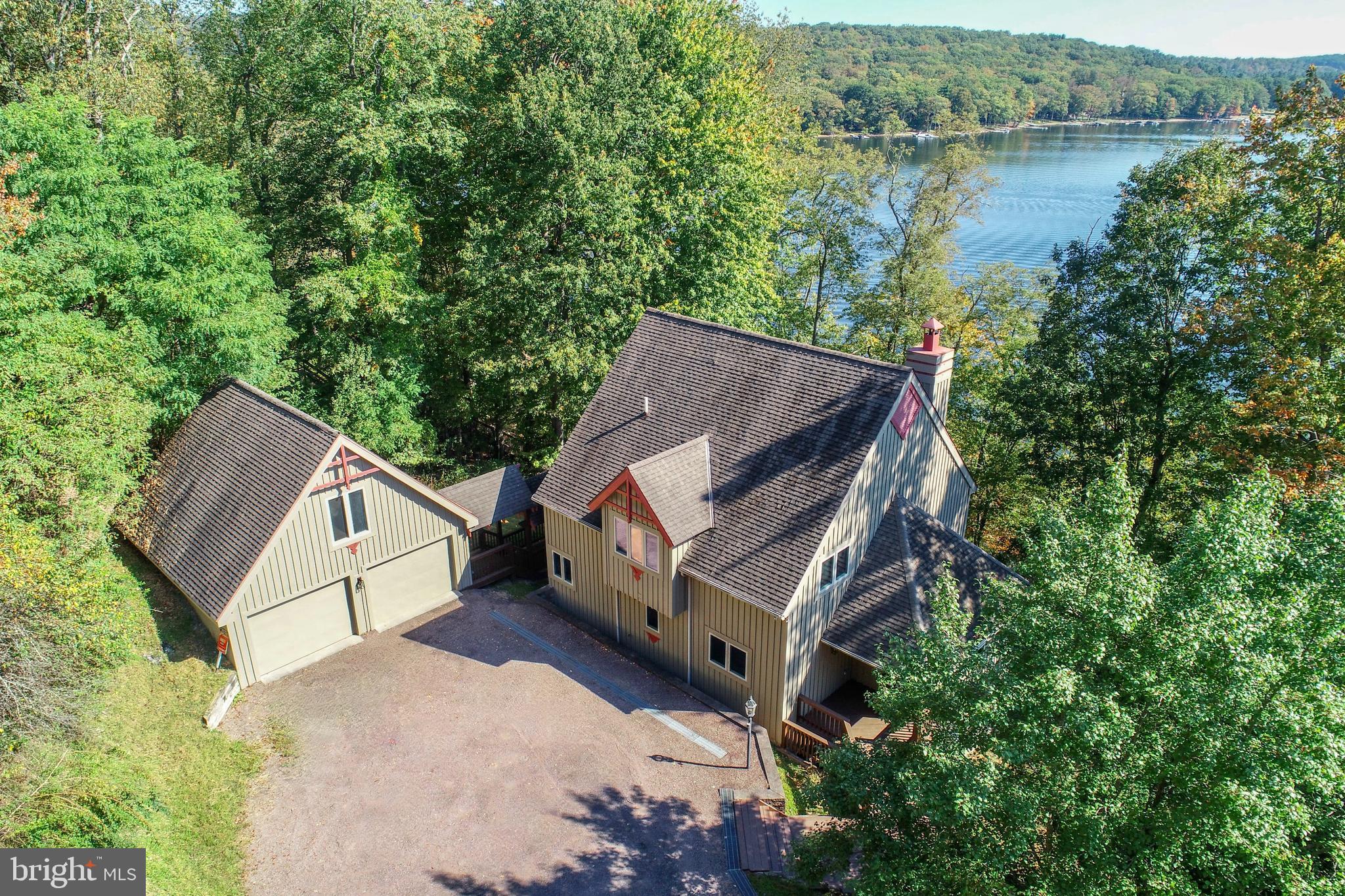 Architecturally unique, private and spacious, lakefront home with a perfect central location!
Step into a home that blends striking architectural design with the best of lake living. The living room showcases a dramatic wall of glass and a floor-to-ceiling stone fireplace, while a large glass-walled rec room on the lower level offers another light-filled space to relax or entertain. This 5-bedroom, 3-bath residence includes a spacious private primary suite with its own balcony, plus a main level bedroom, and three lower-level bedrooms, two overlooking the lake! Multiple decks, and a hot tub with a peaceful water view backdrop.
Enjoy the rare combination of being centrally located yet tucked away in a private setting, giving you both convenience and privacy. With a 2-car garage, private stairs leading to the boat slip, and the advantage of being an affordable lakefront opportunity. This property is perfectly designed for enjoying all Deep Creek Lake has to offer!
Highlights: Architecturally distinctive design-Wall of glass & floor to ceiling stone fireplace in living room-Rec room with a wall of glass-5 Bedrooms/3 full baths, including 2 lower level bedrooms with lake views-Private spacious primary suite with a private balcony-170' of lakefront for privacy and a boat slip-Hot tub overlooking the water-Multiple decks & outdoor entertaining areas-2 car garage-Affordable lakefront in a private yet central location. A true retreat with the perfect balance of style, privacy, and value!