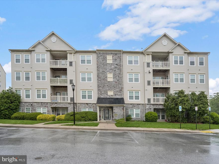 Welcome to this beautifully maintained 2-bedroom, 2-bath condominium in the conveniently located Wyndholme Woods community—just minutes from Catonsville, with easy access to I-695 and Frederick Road. Nestled in a secured-entry building with elevator access, this unit combines practicality with elevated style. Step inside to discover wood-inspired luxury vinyl plank flooring that adds warmth and sophistication throughout the main living areas. The open floor plan connects the dining area—anchored by a striking statement-piece chandelier—to the spacious living room, creating a flexible and inviting space ideal for both relaxing and entertaining. Just off the living room, a sun-filled alcove serves as a charming sunroom or reading nook, complete with an interior window that filters natural light throughout the unit. From here, step out onto your private balcony for a breath of fresh air and a peaceful outdoor retreat. The living room includes a pass-through to the generously sized kitchen, which features ceramic tile flooring, stainless steel appliances, a double sink, granite countertops, a breakfast bar, and a large pantry—perfect for any home cook. The primary bedroom offers a walk-in closet and an en suite bath, while the second bedroom is thoughtfully positioned on the opposite side of the unit, along with a second full bath, providing privacy and convenience for guests or roommates. Whether you're seeking low-maintenance living or a well-appointed home near Catonsville’s amenities, this condo delivers comfort, style, and unbeatable convenience.