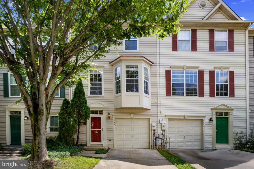 Beautifully maintained townhouse offering 1,760 square feet of comfortable living space with 3 bedrooms, 2 full baths, 1 half bath, and a 1-car garage in the peaceful community of The Sanctuary. Step into a welcoming entry-level foyer with a convenient powder room. Just down the hall, a spacious recreation room provides walk-out access to the backyard and includes laundry facilities—perfect for everyday functionality or casual entertaining. Upstairs, the kitchen features a tile backsplash, select stainless steel appliances, ample modern cabinetry, and a cozy dining area with sliding doors that open to the deck. Adjacent is the inviting living room with a fireplace, creating a warm and relaxed atmosphere. Across from the kitchen, a formal dining room or sitting area with charming bay windows adds flexible space for entertaining. The upper level offers three generously sized, carpeted bedrooms and two full bathrooms. The primary suite boasts soaring vaulted ceilings, a walk-in closet, and an en-suite bath with dual sinks. Additional hallway cabinetry provides convenient extra storage. Enjoy outdoor dining or peaceful relaxation on the deck, which overlooks the luscious backyard.