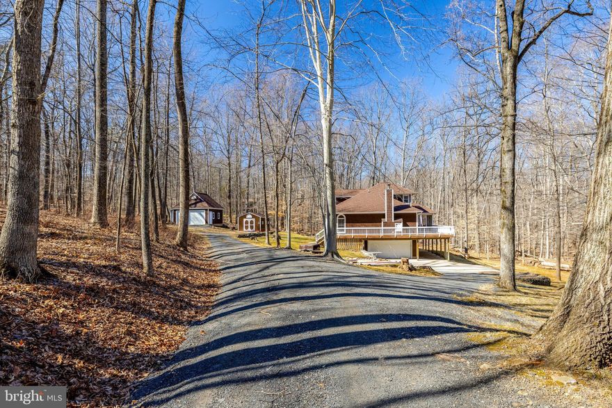 Beautiful home situated on a 5-acre wooded lot with a 1st floor primary suite.  You will enjoy living in the country but  you will be close to everything Haymarket and Gainesville boast.  Main level living at its best with pine rustic hardwood flooring, primary suite with a luxury bath including a jetted tub, second hookup for washer/dryer, plenty of closet space and access to screened in porch.   Kitchen has plenty of custom cabinetry, SS appliances including double ovens, a family room with a stone fireplace,  Harmon Pellet stove and direct access to large deck and don’t miss the extra bedroom with full bath and closets.  On the upper level you will find a loft which adjoins the 3rd bedroom and 3rd full bath including a storage area. This home has a walkout lower level with a bonus room, full bath, storage area with rough in, laundry/utility room and direct access to the large two car garage.   There is plenty of garage space and storage with the oversized DETACHED GARAGE and shed.   Enjoy being outdoors at the small patio with a firepit.   Property has easy access with a circular driveway.  This home has been well maintained, new roof and gutters, HVAC 2020, Water heater 2020, some newer windows, both sliding glass doors one in the primary bedroom and one in  the family room have been replaced.