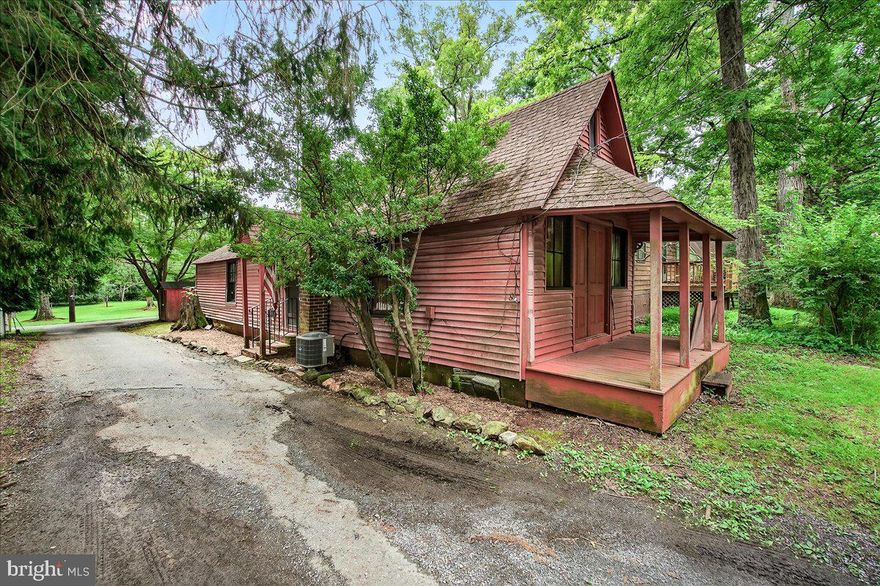 Welcome to The Grove House, a true architectural cottage nestled in the heart of Washington Grove, MD. Built in 1875 and never altered, this original one of a kind track house is a living testament to a simpler, more connected way of life. With 2 bedrooms, 1 full bath, and 742 square feet of thoughtfully preserved space, this slightly tilted cottage is waiting for your vision and offers rare character with modern functionality. Modern updates include a new AC and heating system (2017) and a water heater (2020).
The home’s unique design—with a steep-pitched roof and arched gable frame a narrow, high-ceiling interior with no hallways that exudes charm. Twin porches offer both privacy and community. A hallmark of The Grove House is its front porch, opened by two large wooden doors on the gable end, echoing the tradition of porches as social centers of town life. Facing the now-pedestrian First Avenue, your evenings can be spent strolling tree-lined paths that have welcomed generations.
Nestled in a town honored on the National Register of Historic Places, The Grove House embodies the essence of “A Town within the Forest.” Here, homes blend naturally into the wooded landscape, creating a peaceful, almost magical environment. Enjoy access to town amenities including McCathran Hall for concerts, a gazebo for gatherings, sports fields, tennis courts, and scenic parks perfect for wandering.
With MARC train service just outside the town and I-270 nearby, you can commute to the city with ease—then retreat home to history, beauty, and a deep sense of belonging. The Grove House isn’t just a home. It’s a retreat home to history.