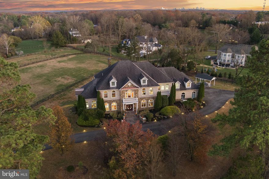 627 Walker Road, Great Falls, VA

A Grand Versailles Custom Estate on Two Pristine Acres

Perfectly positioned just a quarter mile from the Great Falls Village Centre, this commanding, custom-built Versailles estate rests on a beautifully elevated 2-acre corner lot at Walker Road and Arnon Chapel. Built by Versailles Custom Homes for the builder himself, the residence embodies exceptional craftsmanship, timeless materials, and a layout designed for luxurious living and effortless entertaining.

Estate Setting & Exterior

Located in the heart of Great Falls—an area celebrated for its large lots and premier estates—this property offers unmatched presence. The home sits high on a level, mostly cleared corner lot, approached by a sweeping circular driveway that connects both road frontages and a second circular motor court at the front door.

Constructed of brick, stone, and precast architectural detailing, the residence presents a stately façade. A 3-car side-load garage and an additional parking pad accommodate multiple vehicles. Elegant landscape walls flank the front walkway leading to double mahogany entry doors with leaded-glass architectural windows.

Main Level – Grand Scale Living

Stepping into the foyer, guests are greeted by dramatic porcelain tile flooring, a soaring space, and immediate views of the home’s refined formal areas. A formal living room sits to one side and a spacious dining room to the other, each appointed with elegant millwork. A sweeping curved staircase anchors the main level with architectural drama.

Behind the living room is a bright conservatory/music room, while a handsome library w/double French door, built-ins, and a bay window overlooks the rear yard and surrounding pastoral views.

The expansive family room—one of 3 fireplaces on this level—flows seamlessly into the updated gourmet kitchen, breakfast area, and a cozy sitting space. The kitchen, recently renovated and never used, features a Sub-Zero refrigerator, premium cooktop and ovens, warming drawer, microwave, and a built-in cappuccino machine. A butler’s pantry connects directly to the formal dining room.

Practicality meets luxury w/a large laundry room, walk-in pantry, family bathroom with shower (ideal for coming in from the yard or garage), and a formal powder room. In total, the home encompasses more than 9,000 sq ft of refined living space.

Upper Level – Luxurious Private Suites

A circular upper foyer leads to 3 spacious secondary bedrooms, each offering hardwood floors, crown molding, walk-in closets, and en-suite baths featuring designer tile.

The primary suite is a true retreat, with double doors leading to a private sitting room featuring a 3-sided fireplace and access to a veranda - perfect for morning coffee. The expansive primary bedroom is filled with natural light and connects to a spa-inspired bath w/a separate shower, Jacuzzi tub, dual vanities, makeup area, and private water closet.

Two exceptional walk-in closets complete the suite:
• A beautifully finished standard walk-in
• An enormous, unexpected dressing room w/a center island, extensive built-ins, a cedar closet, space for a desk, and room for ironing or staging wardrobe pieces. This dream closet also includes a private back staircase offering direct access to the garage.

Lower Level – Entertaining, Wellness & Guest Quarters

The walkout lower level provides an entire additional living and entertaining floor. Highlights include:
• A full bar designed as a second kitchen with cooking capability
• A dedicated wine-cellar closet
• Powder room
• Two bedrooms
• Media room
• Large recreation and game area
• Separate exercise room
• Spa bathroom with Jacuzzi, steam shower, extensive towel storage, vanity, and private water closet—accessible from the gym and one of the bedrooms

Glass doors open to a covered patio beneath the deck complete w/a fire-pit area and direct access to the flat, usable rear yard.