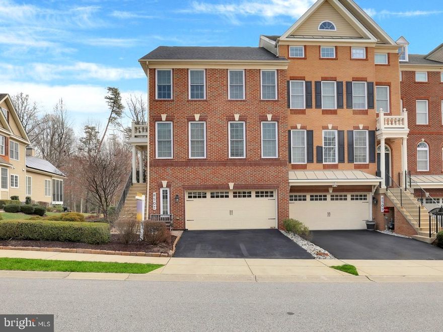 Welcome to 8507 Pine Springs Drive – a beautifully appointed end-unit townhome in the sought-after Arundel Forest community. With its stately brick front, elegant elevation, and front-loading garage, this former model home combines luxury, comfort, and smart design. The professionally landscaped exterior and spacious driveway create a warm and welcoming first impression. Step inside through the upgraded glass front door into a grand foyer adorned with gleaming hardwood floors, a neutral designer palette, and a statement chandelier that sets the tone for the rest of the home. To your right, the formal living room features elegant window treatments and custom lighting, while the formal dining room showcases detailed crown molding, classic sconces, and a sophisticated chandelier—ideal for hosting and entertaining. Continue into the spacious family room, where hardwood floors extend throughout, seamlessly connecting each space. Integrated speaker systems elevate the ambiance, and natural light pours in from the surrounding windows. The adjacent morning room is a showstopper with its coffered ceilings, three walls of windows, and tranquil views, creating the perfect space to relax or entertain. The gourmet kitchen is a chef’s dream—outfitted with stainless steel appliances, 42” custom cabinetry with crown molding, under-cabinet lighting, upgraded granite countertops, a dramatic herringbone marble backsplash, black hardware, and a deep farmhouse sink. Additional highlights include a wall oven with built-in microwave, a large walk-in pantry, a butler’s pantry, bar-height seating with pendant lighting, and a sunlit breakfast area with direct access to your private deck—perfect for morning coffee or evening unwinding. A stylish powder room with designer tile accent wall completes the main level. Upstairs, retreat to your luxurious primary suite featuring soaring cathedral ceilings, built-in speakers, and a generously sized walk-in closet with custom built-ins. The private sitting area is surrounded by windows on three sides, offering both serenity and natural light. The spa-inspired ensuite bath features a soaking tub, frameless glass walk-in shower with marble tile and bench seating, double granite vanities, upscale hardware, and a private water closet. Two additional bedrooms offer vaulted ceilings, designer window treatments, and generous closet space. A beautifully appointed hall bath with luxury tilework and an upper-level laundry area complete this level. The finished lower level is an entertainer’s haven, featuring a media wall with three built-in TVs, custom wood-paneled accent wall, built-in storage, a billiards space, and a bonus area perfect for an office or creative studio. Step outside to your fully fenced backyard retreat with a paver patio, built-in retaining wall, tranquil water fountain, additional storage shed, and lush landscaping—ideal for relaxing or entertaining in complete privacy. This energy-efficient smart home includes dual 92% efficient gas heating systems, a high-efficiency HVAC system, Nest programmable thermostat, Tyvek HomeWrap, Low-E dual-pane insulated windows, upgraded attic and wall insulation, air barrier and duct sealing, 2x6 exterior framing and an insulated steel garage door. A 35-year architectural roof adds even more value. Arundel Forest residents enjoy resort-style amenities including a clubhouse, fitness center, outdoor pool, gated playground, scenic trails, and picnic areas. Located just minutes from premier shopping and dining, with easy access to Fort Meade, Columbia, Baltimore, Washington D.C., BWI Airport, and Arundel Mills—this is luxury living at its finest.