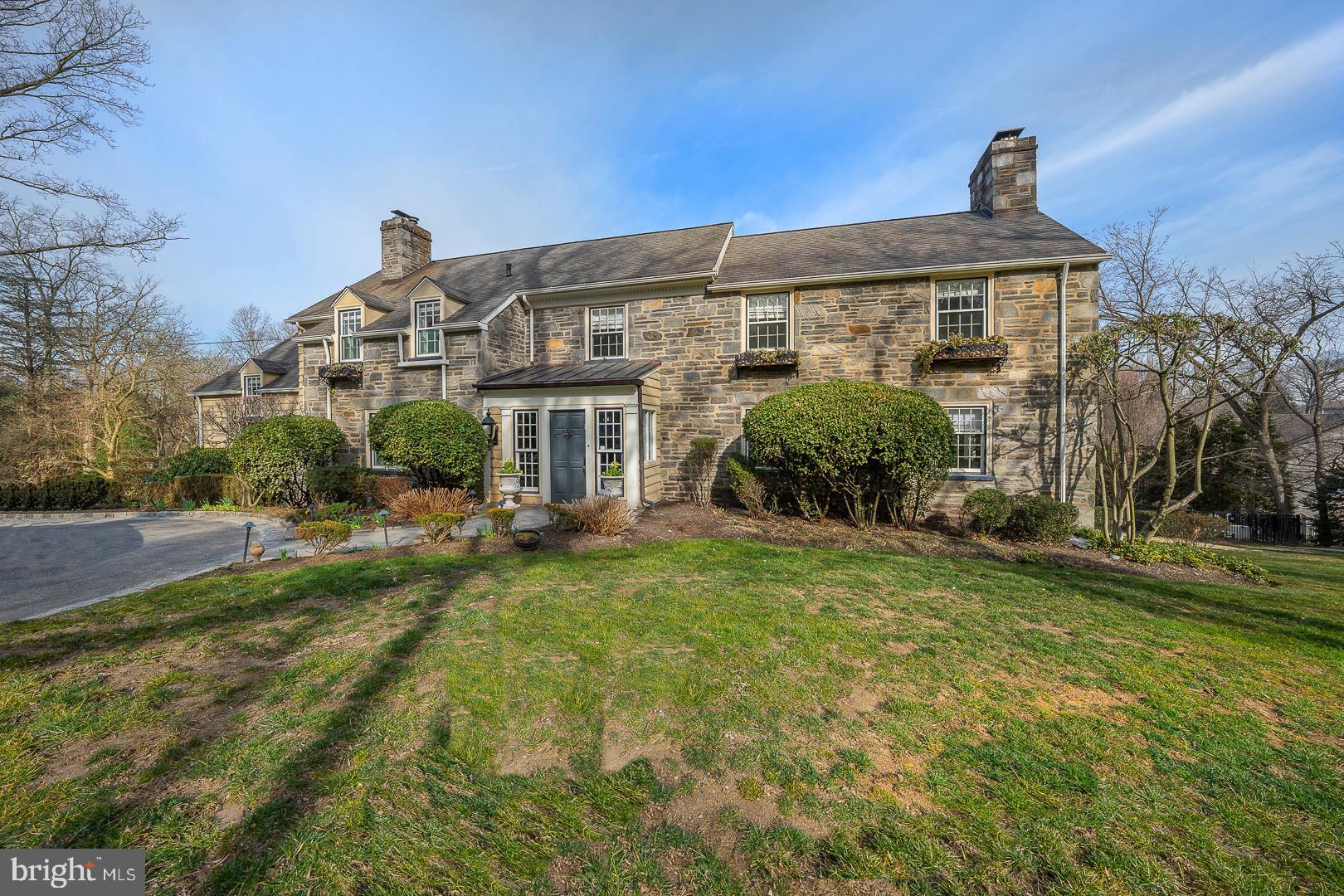 This stately Main Line stone center hall Colonial is welcoming to any buyers! There is nothing to do but move in. Four fireplaces, 5 bedrooms, 4 full bathrooms, and 2 powder rooms. Eat-in Kitchen features a fireplace, granite counters, an extra large center island with plenty of room for stools, 2 sinks, DCS stove, storage galore, many bright windows. Rear staircases from kitchen descend down to mud-room and very oversized 1 car attached garage. They ascend up to a large pantry, two smaller bedrooms, and a full bath. Don't miss the powder room off of the kitchen. Lower level access from the staircase to a large finished room with another fireplace, powder room, laundry, and awesome enclosed porch area leading out to yard and pool. Formal entry into the home is through a lovely vestibule into Center Hall grand in scale. The magnificent living room with fireplace and windows around. There is also a door heading out to a veranda with a staircase to the yard and pool. tucked behind the staircase you find a dining room large enough for the entire extended family to come, and both the living room and dining room open onto an elegant slate veranda, partially covered. The Owners suite is complete with a fireplace, dressing room, private outdoor deck, and an en-suite bathroom with a spacious walk-in shower. There are many more wonderful things to see including a built-in pool with space for tons of chairs and potted plants. House was completely changed over from a septic system to public sewer connection in 2022, along with many other updates that have been done in the last few years, including newly refinished floors, a new garage door, newer stove and dishwasher, and a cedar closet in the attic. Don't miss this wonderful gem of a home!