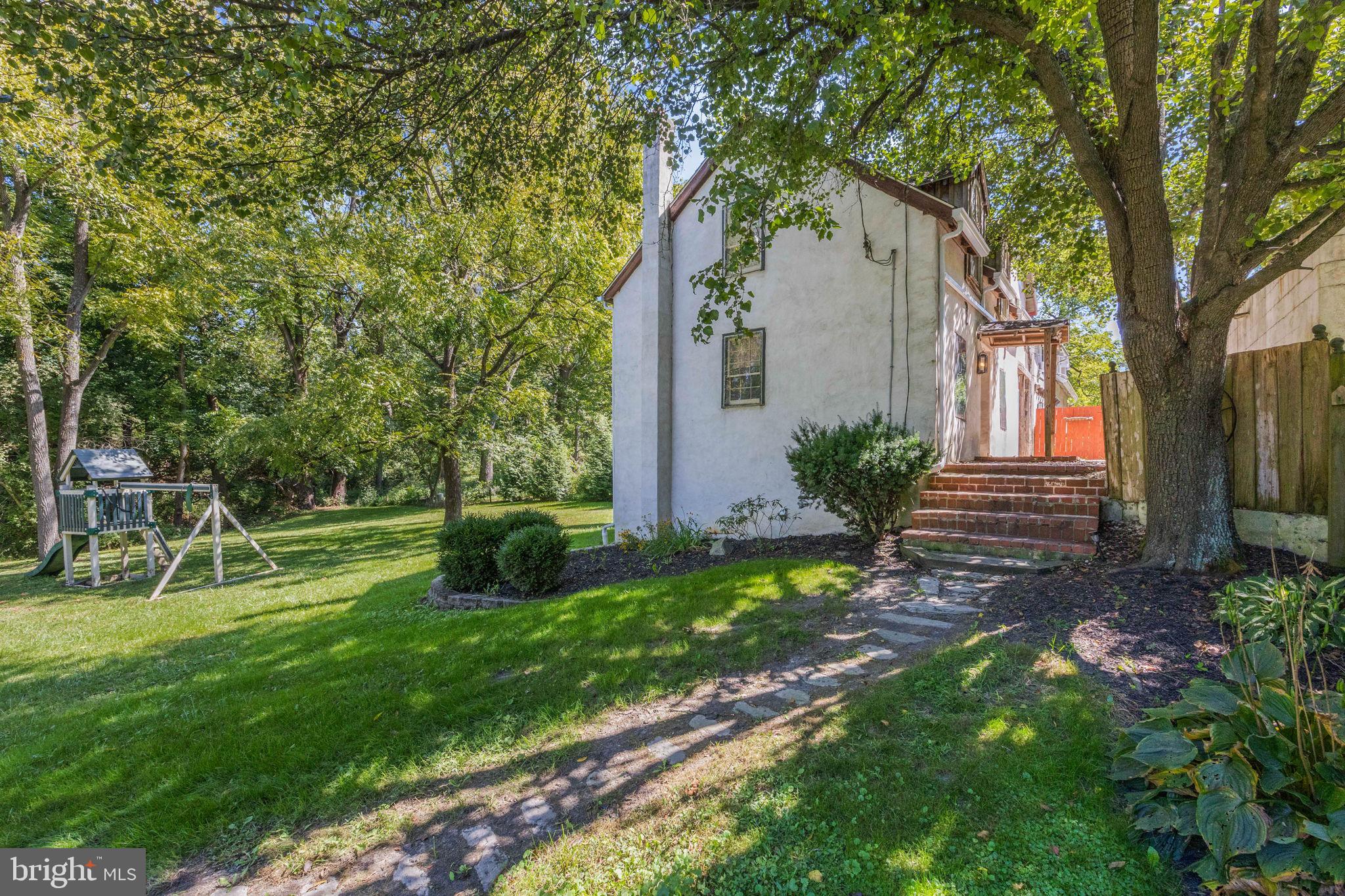 Historic mill house, within site and walking distance of the Octorara Lake, is ready to charm old house lovers who are looking for a home to display their antiques! This scenic lot has a stream with an adorable footbridge – cross the bridge to reclaim the charming rock garden area that the Seller created during her original renovations. The house underwent a major renovation in 1993 with new baths, kitchen and lots of updates inside and out. Enter to the captivating dining room with stone fireplace and gleaming wood floors. Adjoining kitchen has custom cabinets with generous counter space and beamed ceiling. Electric range, dishwasher, microwave and double sink aid in your domestic chores. Ceramic tile backsplash, recessed lights and original wood floors complete the space. Large living room, with beautiful stone fireplace, features wood floors and prado doors to flood the room with light. Charming winder stairs lead you to the second floor. Primary bedroom is generous sized. Adjoining bath features a stall shower, claw foot tub and vanity. 2 additional bedrooms are served by the hall bath with pedestal sink, tub and a linen closet. Descend to the lower level walkout family room with so much charm! A wall of built ins and laminate floor combine with a natural spring pond, that is currently covered but has been displayed by past occupants. Laundry area combines with the utility room featuring an electric hot water heater and economical natural gas hot water heat. The roof has been replaced in the last 5 years. Finally, enjoy the quiet rear yard, off street parking and storage shed to complete the picture.
