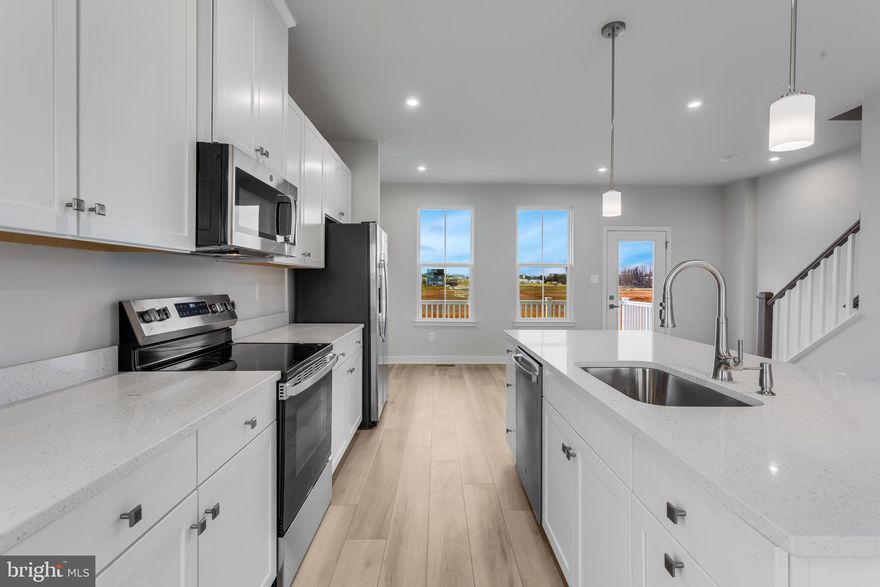 Welcome to the IMMEDIATE MOVE IN BALLAD END UNIT at the brand new MADISON GREENS community in Ranson, WV! Luxury townhomes that live like a single family home with backyards and a prime location walkable to Potomac Towne Center and right off Rt. 9. Only 20 min from Frederick County, MD and 30 min from Loudoun County, VA. Step inside through the welcoming ground-floor foyer, leading to a versatile oversized recreation room with a powder room. Upstairs, an expansive great room offers the perfect setting for relaxing or entertaining. The adjoining gourmet kitchen, complete with a generous island, walk-in pantry, and open dining area, makes cooking and gathering a true delight. On the third floor, discover two comfortable secondary bedrooms and a full bath. Retreat to your luxurious owner’s suite, featuring dual walk-in closets and a spa-like bath with double vanities. Every Ballad includes a private backyard — the perfect spot for enjoying fresh air or giving your furry friend room to play. Come visit our model home at: 1741 Destrier St, Ranson, WV, 25438