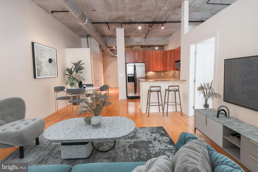 Welcome to Unit 5E at The National Condominiums, a stunning residence nestled in the heart of Philadelphia’s historic Old City neighborhood. This modern unit offers 1,080 square feet of thoughtfully designed living space, featuring two bedrooms and two bathrooms that promise comfort and style.

As you enter, you are greeted by natural wood floors that seamlessly flow throughout the home. The open floor plan creates a welcoming atmosphere, with a spacious living room perfect for relaxation, enhanced by custom plantation shades. Adjacent is a cozy dining area, ideal for intimate meals or entertaining guests. The U-shaped kitchen is a chef’s delight, equipped with contemporary wood cabinets, stainless steel appliances, and a sleek granite countertop.

The primary bedroom is a tranquil retreat, offering large windows that frame picturesque views of historic Elfreth’s Alley and Flag Park. It includes a closet-border walkway leading to the elegant primary bath, which features double sinks and a glass-enclosed shower. The guest bedroom is equally inviting, with a generous closet and additional cubby storage space. Guests will appreciate the well-appointed second bathroom, complete with a single sink wood and granite vanity and a tub-shower combo.

Convenience is key in this home, with a large laundry closet situated off the foyer, providing space for a washer and dryer.  The building enhances lifestyle conveniences with an elevator, secure package handling, ample common area outdoor space with seating,  and a secure garage with assigned parking.
Situated in a vibrant cultural hub, Old City is renowned for its rich historical heritage, theaters, and diverse dining options. Enjoy easy access to public transportation for convenient commuting throughout the city.

Experience luxury living in a historic setting at Unit 5E, where the charm of the past meets modern living. Arrange a viewing today and discover your new home!