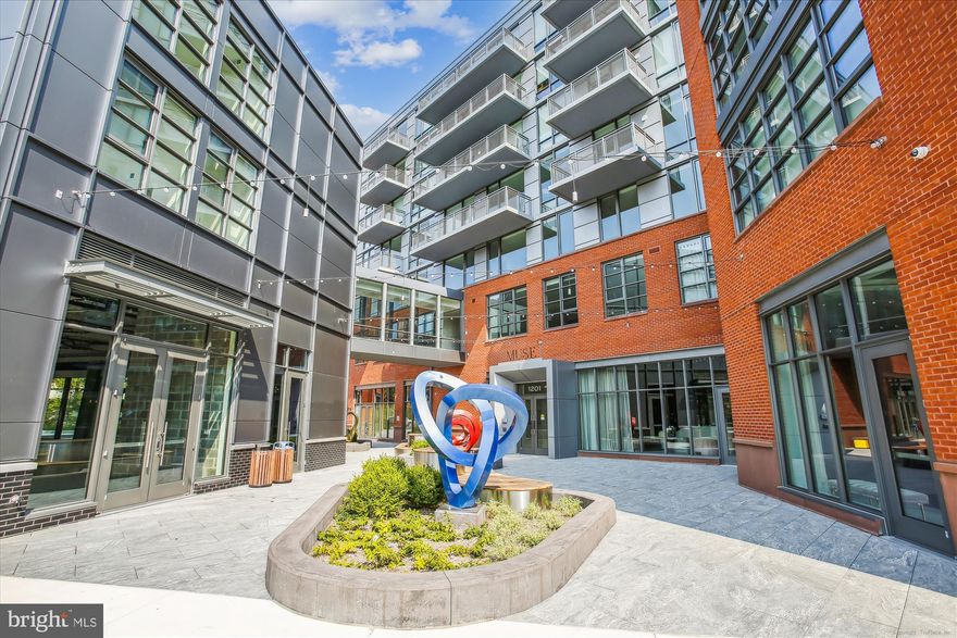 Assumable 3.25% VA Loan opportunity.

Welcome to MUSE Condominium! This one bedroom plus den is in the perfect location for easy access to everything the DMV and Alexandria have to offer. This is easy living and luxurious amenities at its best. This location is and will be in a prime spot for the new developments underway in North Old Town.

This unit with 13 foot ceilings lives BIG and offers stylish, comfortable living with access to all that the amenities that MUSE has to offer such as 24-hour concierge service. The MUSE roof top boasts the Watercolor Lounge and fitness center offering panoramic views of DC and Alexandria. The garage has a dog washing station for the furry ones and secure bike storage.

The owners have added several upgrades to the unit such as $5K of premium light fixtures from Arhaus and Pottery Barn and a motorized upgraded blackout shade in the primary bedroom. The den has been outfitted with a multifunctional wall bed that changes from desk to bed in seconds.  

Check out the video for the LGM model wall bed from Resource Space Reinvented . The owners custom-selected materials to seamlessly blend with the cabinetry throughout the unit. This maximizes the usefulness of the den by solving the common need for both an office and a room for guests. Take advantage of their $20K+ investment in quality and functionality.

From the 150+ sqft outside patio, there is direct access to the Mount Vernon Trail which allows for an easy walk to the river and center of Old Town.

This unit comes with an assigned garage space and a storage unit on G1.