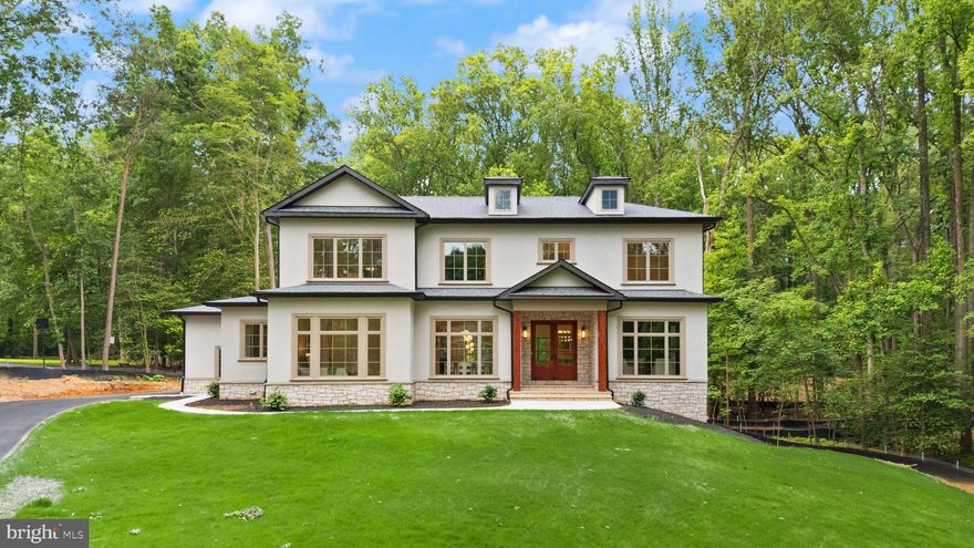 This custom new build by award-winning Faber Custom Builders is set on nearly two private, wooded acres in an established Great Falls neighborhood. Blending timeless architecture with thoughtful modern design, the home features a stucco exterior, deep-toned Pella windows, and a solid mahogany front door for a warm, elegant welcome.

Inside, the open-concept layout is ideal for both everyday living and entertaining. The chef’s kitchen includes custom cabinetry and connects to a hidden scullery-style pantry with a beverage bar, offering extra prep and storage space. A see-through fireplace connects the great room to a covered porch, creating a seamless flow between indoor and outdoor living.

A modern mudroom, separate guest entry, and main-level guest suite provide convenience and flexibility. The formal dining room sets the stage for special occasions, while a private home office adds functional workspace.

Upstairs, four spacious bedrooms each feature en-suite bathrooms and walk-in closets. The luxurious primary suite showcases a dramatic black marble accent wall, beautiful natural light, and curated designer finishes. A large upstairs landing/lounge and well-designed laundry room make this level a comfortable retreat for the entire household.

The finished lower level includes a generous recreation room, cinema complete with music-sync lighting, lounge, and wellness retreat with built-in Sauna.