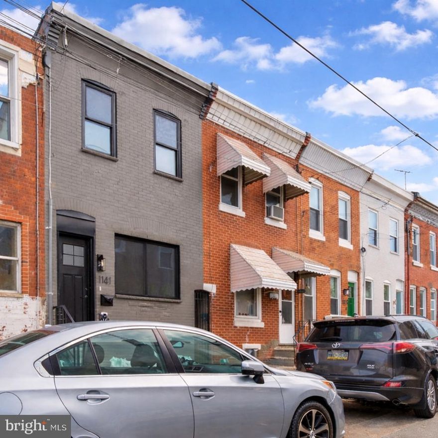 New! Conceptual rendering of finished basement included! Prepare to fall in love! Top-quality renovation, refined selections, premium location seconds from Passyunk Avenue attractions, dual primary suites each with private baths! Dramatic curb appeal with slate-gray brick exterior, black-trimmed windows, solid marble steps, bold black entry door. Wide-open main-floor layout with wide-plank white oak floors, striking exposed brick accent wall, sculptural steel-and-wood staircase with solid wood treads, sleek black steel balustrades, wood railings. Convenient main-floor powder room, thoughtfully designed eat-in kitchen with custom two-toned cabinetry, brushed gold hardware, undercabinet lighting, modern vertical tile backsplash, sleek quartz surfaces, undermount sink, industrial-style pull-down faucet, stainless GE appliance package including French-door refrigerator with in-door beverage dispenser, excellent cabinet and counter space. Step out to private courtyard. Rear bedroom with flush-mount LED fandelier, private sumptuous bath featuring tub/shower combination, earthy hand-glazed tile, frameless glass barndoor enclosure with chic matte-black hardware, geometric tile flooring, furniture-style vanity with drawers. Bright front bedroom with modern enclosed fandelier, double closets, luxurious Jack-and-Jill bath with cabinet-style vanity and frameless glass shower with rainfall shower head and floor-to-ceiling porcelain tile. Partially finished basement with painted joists, inset LED lighting, crisp parged walls, painted floor. Conceptual rendering showing potential finished basement layout; seller open to discussing completion or credit depending on offer terms. All-new plumbing, electric, HVAC, and roof. Walk to beloved Passyunk Avenue with its over 50 shops, boutiques and numerous James Beard-recognized restaurants; outdoor enthusiasts will fall in love with Columbus Square Park, featuring 3.6 acres of green space with two dog runs, a rose garden, nature walk, and water-fountain play area. 10-year tax abatement application pending. Location, quality, design — it doesn’t get any better! Shows beautifully!