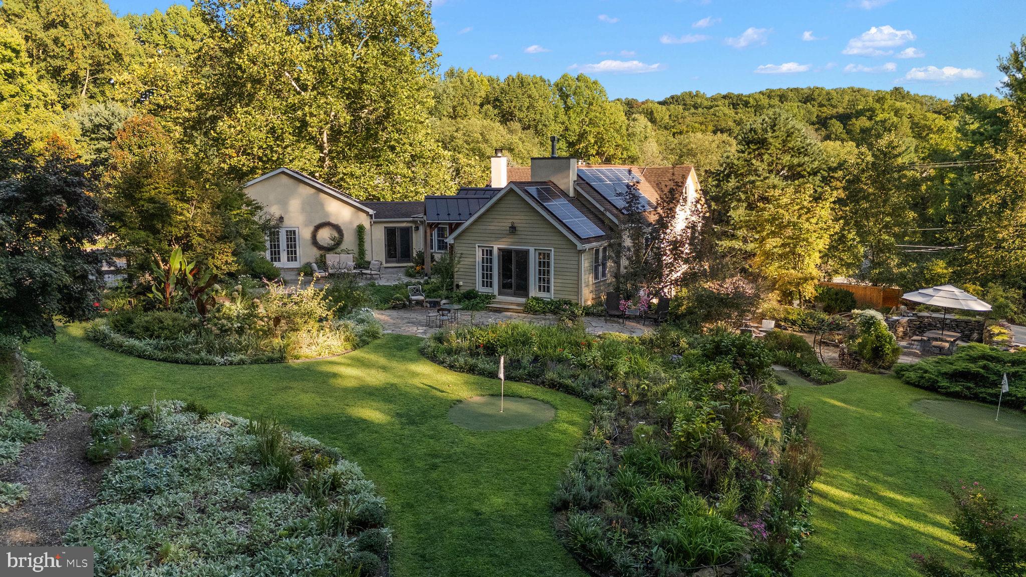 Whether you’re a history buff who would love to live in the 5th oldest structure in PA, a golfer who would likes to practice at home, or you simply appreciate the proximity of the Unionville-Chadds Ford school district this amazing custom home can be yours. The core of the home was a c 1660 Trading Post used by the Lenape Indians! The additions to the home were primarily completed in 2013, so it's a mix of antiquity and modern conveniences.
When you step over the threshold from under the custom designed canopied doorway, you’ll see one of the original “log cabin type” walls from the trading post. An Amish-built addition doubled the size of the house, making it possible to expose the historic log walls and have the primary bedroom and bathroom on the same floor as the open living room which is graced by an enormous fireplace framed by 1800’s timber from the super-fine grade flour mills in Delaware. A practical kitchen with multiple granite work surfaces and stainless appliances opens to an eat-in dining area as well as a very cozy den with wood burning fireplace and a vaulted ceiling exposing more of the original historic style. From the eat-in area is an oversized 2-car garage with vaulted ceiling and chandelier!. Freshly painted and decorating the tall walls are boards pulled from the original trading post. On this floor is the primary bedroom with exposed 1660 timber walls, a walk in closet and en-suite bathroom. For privacy you can close off the den/primary suite. Rounding off this floor is a sunroom, currently used as an office, and could be used for multiple other options.
From the living room take the side stairwell to the top floor of the trading post and enter the “eaves” of the home. This tucked away room will surprise you with size for queen bed, desk , tv, fireplace, and – an en-suite bathroom that includes a small refrigerator and microwave AND a washer/dryer combo! Talk about setting up guests!
Now let’s go back down to the lower level or what would have been the second floor of the trading post, but has a ground level entrance. As you go down the stairs, note the historic timeline of the home enumerated on the walls from prior owners and influencers.
In 2013 this floor was transformed into three generous bedrooms, 2 bathrooms (one en-suite) and laundry, an enclosed porch/study, a full kitchen with a separate bar and a family room with a fireplace! This room opens to a large patio with a tiered stone patio with electricity and water. One of the many charming features are the cork “walls” near the wet bar and under the stairs, used as sound proofing so the first floor guests won’t hear people coming down the stairs late at night. Each area, inside & out is unique from each other.
If charm, history, convenience aren’t enough, this home includes 2 brand new heat pumps for heating and cooling, 2 propane-burning fireplaces, 1 wood-burning fireplace and 1 eco-friendly electric fireplace.
Speaking of the amazing gardens, take a look at the photos and see if you can see one of the nine par-3 chipping greens! Creating further opportunity for fun for all their guests, the owner over time built expansive gardens with 9 holes tucked away. Friendly competitions ensue! Throughout the property you’ll find meandering paths, water features, sand traps for golf and children’s castles, and many seating areas to enjoy a book or nap. Pennsylvania fieldstone retaining walls merge with the antiquity to create this dreamlike oasis.
If you’re looking for that next unique and charming home for your everyday use, a weekend retreat, or an expansive guest and party house that offers modern living and an incredibly convenient location, you must see this home today! Touring the house in person will speak volumes that are difficult to describe. We’re looking forward to seeing you there!