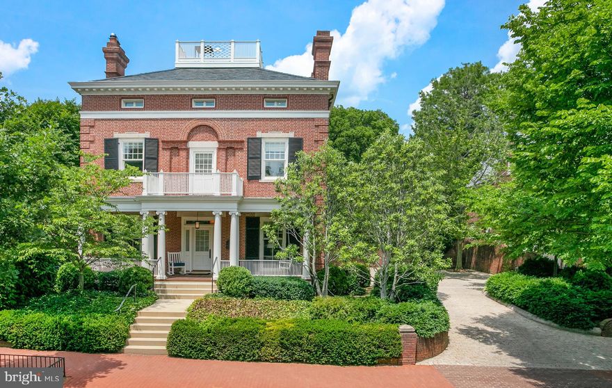 Ideally located in the heart of Georgetown’s prestigious East Village, this handsome detached residence is located on a .23-acre lot and exudes grandeur. The Colonial Revival-style home was constructed in 1893 for the daughter of Thomas Hyde, a prominent Washington DC businessman, who worked directly with the architecture firm of Snowden Ashford and Howard Sill. The house remained in the Hyde-Wright family until the early 1960s, when the owner and occupant of the adjacent estate Evermay purchased the property. The new owner made significant changes to both the interior and exterior of the existing structure. The residence now has a commanding street presence at 28th and Q Streets, set back from the street to capture incredible light from all directions. The classic brick façade offers impressive curb appeal, and the interior offers a wonderful balance of sophisticated entertaining rooms and warm family living spaces. Award-winning architects Cunningham|Quill, Horizon Builders, and interior designer Thomas Pheasant worked together in a custom collaboration to completely transform the home using the highest quality design, fixtures, and finishes. The main level is set above the street and features an open, flowing layout, perfect for entertaining. The gracious foyer has beautiful moldings and is lit by a lovely transom window above the front door. It leads to the elegant formal living room and dining room, which are complemented by two exquisite marble wood-burning fireplaces, high ceilings, and elegant moldings. There is also an office with an additional fireplace on this floor. The chef’s kitchen has an attractive coffered ceiling, radiant floor heating, a large center island, custom cabinetry, and top-of-the-line stainless steel appliances. The eat-in kitchen adjoins the family room, which is enhanced with floor to ceiling windows and doors to the dining terrace and private gardens. There is the added convenience of a powder room and a large mudroom/pantry with abundant storage. The stunning original staircase leads to the generous second level, which is flooded with sunlight from an original Palladian window with dentil moldings and columns. The luxurious primary suite encompasses over half of the second floor and is flooded with sunlight from walls of floor-to-ceiling windows. It has a beautiful coffered ceiling and an impressive walk-in dressing room with built-out closets. There is also a well-appointed en-suite bathroom with radiant heat floors, dual vanities, a frameless glass shower, and separate soaking tub. The primary suite adjoins an attractive private sitting room/library with a wood-burning fireplace and a built-in desk and shelving. There are two additional bedrooms on this floor that capture abundant sunlight and share a bathroom. All bathrooms have Waterworks tile and the sinks and fixtures are Dornbracht. There is also a washer and dryer on this level for added convenience. The third floor has three bedrooms, all with en-suite bathrooms. There is also wonderful roof deck that is a great for entertaining and provides spectacular views of DC and the Washington Monument. The lower level is beautifully finished and has two separate suites, one of which has a full kitchen and an additional laundry room, perfect for accommodating guests or staff. A gracious hallway leads to the theater room, wine cellar, kitchenette, and powder room. The house also has five geothermal wells with seven zones, plus five radiant floor heating system zones. The extensive rear grounds are exceptionally private and wonderful for entertaining, featuring mature trees, multiple terraces, and professionally designed gardens by landscape architect Richard Arentz. There is also a pool-sized flat yard and a motor court with parking for 6 cars.