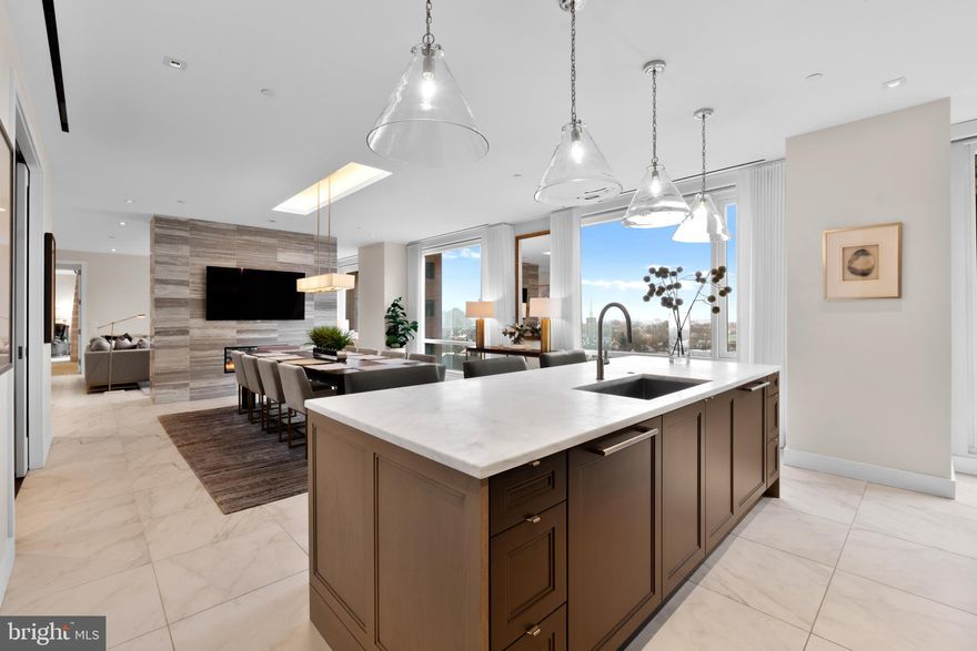Rarely offered on the market, the south-facing 10th-floor Residence is a breathtaking 3-bedroom, 3.5-bathroom home located in the iconic 500 Walnut. This distinctive building, designed by the esteemed architect Cecil Baker, represents a unique boutique luxury condominium positioned in Society Hill, just off Washington Square. Step into this light-filled space through an elegant gallery featuring high ceilings that flow seamlessly into the open living and dining area, adorned with floor-to-ceiling windows and southern exposures. A striking feature wall separates the rooms, outfitted with a gas fireplace, built-in television, and a custom-lit art gallery. The kitchen, expertly crafted by Joanne Hudson, boasts marble countertops, under-cabinet lighting, and top-tier appliances, including a Sub-Zero refrigerator, Wolf oven, microwave, stovetop, Asko dishwasher, and a beverage station complete with wine storage and two drink drawers. Adjacent to the kitchen is a pantry with glass pocket doors and thoughtfully designed storage. The primary suite offers a private south-facing balcony, a luxurious walk-in closet, a wine fridge, and a coffee station. Its bathroom is equipped with a double vanity marble sink, an oversized shower featuring a waterfall showerhead, and radiant heat flooring. The spacious second bedroom includes ample closet space and its own en-suite bath. The third bedroom, currently functioning as a den and home office, opens from the living area through large pocket doors and overlooks Independence Park. Additional features include a sizable laundry room with substantial storage, Lutron motorized window shades, LED lighting, an audio speaker system, porcelain floors, and custom carpeting. 500 Walnut offers the convenience of a doorman building equipped with a fully automated parking system, a pool, a fitness center, massage rooms with steam and sauna, a communal area featuring a couple of outdoor fireplaces, a golf simulator, a billiards area, a boardroom, a pet spa, on-site daily chauffeur service, and a guest suite available upon request for out of town guest. This residence benefits from approximately three years remaining on the tax abatement and two deeded parking spaces.