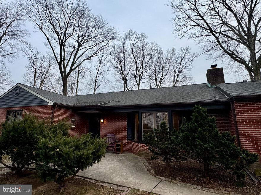 Nestled on a private, wooded property backing to Northampton Valley Country Club, this brick ranch sits on a generously sized parcel in the sought-after Highland Farms neighborhood within the Council Rock School District. Offering a rare combination of privacy, space, and major system upgrades, this home provides both comfort and long-term value.
The home has been thoughtfully maintained and extensively improved. Major upgrades include a geothermal heating and cooling system (2014), new roof (including plywood and shingles) and new siding (2019), a fully renovated hall bath (2022) taken down to the studs with all-new plumbing and electrical, a whole-house propane generator (2020), professional flashing of all windows and exterior doors (2023), two new hot water heaters (2025), and interior painting throughout the home within the last two years.
A spacious horseshoe driveway offers ample parking, and a stamped concrete walkway leads to the front entry. Inside, a convenient coat closet is located just off the foyer. The living room features custom built-ins, a large picture window that fills the space with natural light, and a brick fireplace that serves as an architectural focal point. The kitchen includes granite countertops, a custom tile backsplash, stainless steel appliances and hood, and a gas cooktop