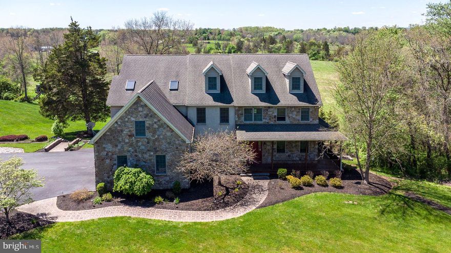 Bucks County estate on over 18 scenic acres, this custom-built Colonial farmhouse–style home offers a thoughtfully designed floor plan, expansive views, and a peaceful setting surrounded by open pastures and wooded areas. The stone and stucco exterior is complemented by newer custom decks on both the first and second levels, providing wonderful spaces to enjoy the panoramic landscape.
The main level welcomes guests with a dramatic two-story foyer that opens to the living room and formal dining room. A two-story family room with a stone fireplace and a wall of windows brings in abundant natural light and overlooks the backyard. A spacious office offers a bright and comfortable work-from-home environment.
The kitchen features stainless steel appliances, granite countertops, gas cooking, and generous workspace. A powder room and an expansive laundry room complete the main level.
Upstairs, the main bedroom suite includes two walk-in closets, a sitting room with fireplace, a large primary bath, a bonus room, and a staircase leading to an additional unfinished attic area offering potential for future use. Additional bedrooms and full baths provide comfortable accommodations for family and guests.
The fully finished walk-out basement features durable luxury vinyl plank flooring and includes a full bathroom, creating flexible space for recreation, hobbies, or extended living.
Additional features include an attached three-car garage, whole-house generator, and a custom in-ground heated salt water pool with spa. A substantial barn offers parking for up to ten vehicles and includes an unfinished second story, providing additional possibilities.
Conveniently located near the shops, dining, and cultural attractions of both Doylestown and New Hope, with access to major commuter routes.