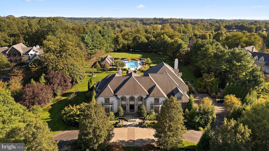 Welcome to 11 Summit Lane, a stunning and elegant modern home nestled in the prestigious enclave of Stoney Run in Wilmington, DE. This remarkable property boasts 6 bedrooms, 7.2 bathrooms, and over 13,000 square feet of living space (as noted in New Castle County tax records), situated on a generous beautifully landscaped lot spanning almost 4 acres. This residence is designed for seamless indoor-outdoor living, with a sprawling backyard and lush landscaping, providing a serene setting for outdoor gatherings and recreation. As you step inside, you are greeted by a grand foyer with marble floor that sets the tone for the rest of the home. The main level boasts a spacious living room with high ceilings and an abundance of natural light, creating an inviting atmosphere for both relaxation and entertainment. Formal dining room is sizeable enough to host large dinner parties, yet also perfect for intimate dining. The home office on the main floor with rich wood accents could also double as a library with gas fireplace and walls of built ins. The main floor is also host to a bedroom suite with private full bath, dressing room, bedroom, and walk-in closet. This multi-functional space can work as a fabulous owner’s retreat, in-law suite, or au-pair apartment. Renovated in 2007, this home underwent an impressive transformation, including a substantial 2-story addition. The addition features a grand family room with a captivating, coffered ceiling, seamlessly connected to a gourmet kitchen that will delight any culinary enthusiast. The second-floor primary suite is a true sanctuary, offering a spacious bedroom, 2 walk-in closets, an elegant home office, and a spa-like full bath, providing the ultimate in relaxation and comfort. The 2nd floor is also host to four additional bedroom suites each with their own full bath and walk-in closet. Huge laundry room with 2 sets of appliances and an abundance of storage makes doing a tiresome chore more inviting.
The finished basement is an entertainer's dream, boasting a well-appointed bar, game room, media room, exercise room, and a versatile bonus room. Additionally, the basement features a room that was expertly dug down further, originally used as an indoor batting cage but offering endless possibilities. Step outside to discover an outdoor oasis, featuring an oversized terrace complete with a kitchen and fireplace, an inviting in-ground pool, nicely equipped pool house, and raised garden beds, creating an ideal setting for outdoor gatherings and leisure. Don't miss the opportunity to make this exquisite property your own and experience the epitome of luxury living. Conveniently located just minutes from shops and dining in Greenville, outdoor recreation in Brandywine Creek State Park, downtown Wilmington/Amtrak station, and under thirty minutes to Philadelphia International Airport.