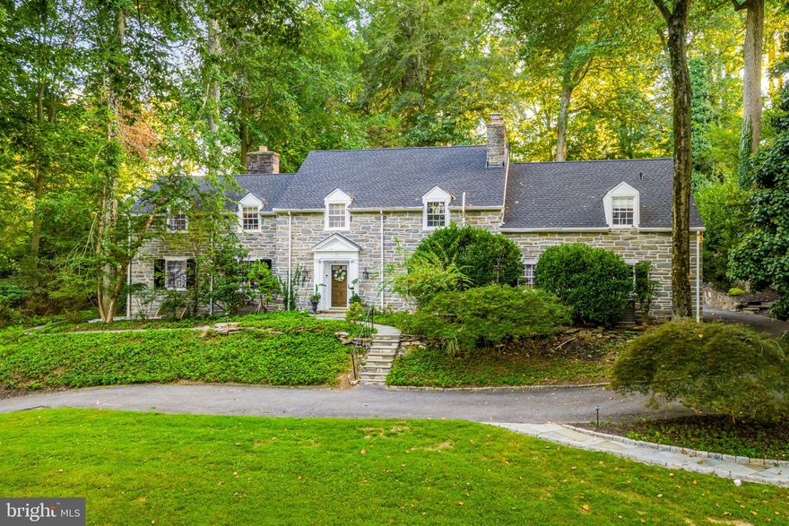Rarely available on tree-lined Winding Lane, this 5-bedroom, 3.5-bath stone country manor marries 1940s craftsmanship with thoughtful modern updates on a private 0.82-acre cul-de-sac lot in the highly rated Wallingford–Swarthmore School District. Offering 4,427 square feet of expansive above grade living space plus a finished lower level, the home welcomes with a gracious foyer, hardwood floors, deep windowsills, elegant millwork, and a sweeping staircase. To the left, a paneled study with a brick-surround fireplace anchors work or reading. Crown molding and classic built-ins amplify the period detail. Sun-filled formal living and dining rooms showcase broad windows, while a window-wrapped sunroom with French doors to the flagstone patio and landscaped grounds. At the heart of the home, the gourmet kitchen features marble counters, oversized island with wine refrigeration, double ovens, pot filler, and custom cabinetry, served by an adjacent large breakfast area. Upstairs, the serene primary suite offers dual walk-in closets and a spa bath with soaking tub, glass shower, and double vanity. Four additional bedrooms, laundry, office space, and updated baths provide flexibility, with the fifth bedroom offering versatility- currently used as a laundry room, but with two windows and a closet, making it ideal for a guest room, home office, or nursery. A finished lower level adds media, game, or fitness space plus plentiful storage. An attached two-car garage and driveway parking accommodate multiple vehicles, while mature trees provide enduring privacy. Moments to downtown Media's dining and shops, regional rail, parks and major routes, this rare offering blends timeless character, modern comfort, and a coveted location on a street where homes seldom come to market.