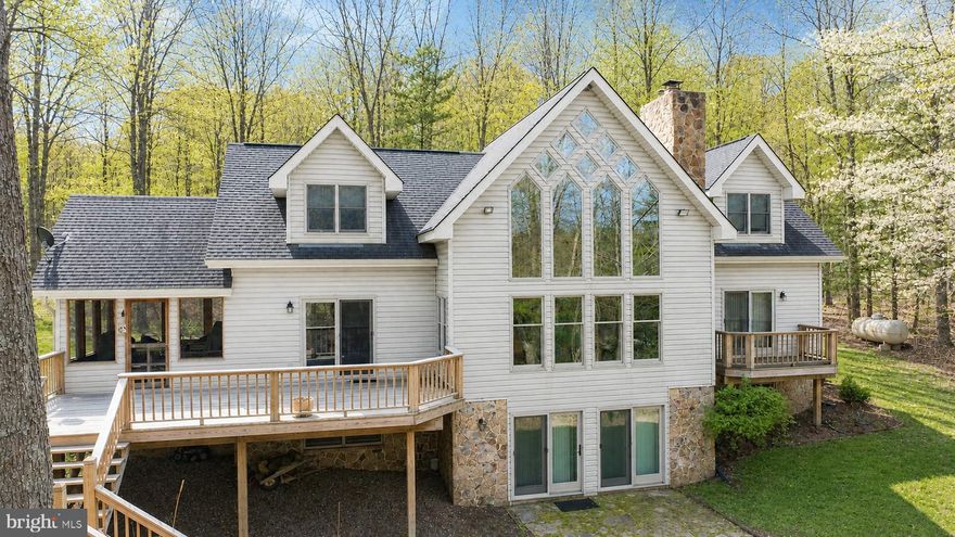 Tucked within the prestigious Thousand Acres community, this stunning chalet-style lakefront retreat offers a rare combination of privacy, space, and sweeping Deep Creek Lake beauty. Set on 1.8 acres with an impressive 125 feet of lake frontage, the property captures the essence of mountain-lake living with over 3,500 square feet spread across three spacious levels. Soaring windows and walls of glass fill the home with incredible natural light while framing breathtaking lake and wooded views from nearly every angle. Featuring 3 bedrooms, 3.5 full baths, and expansive gathering spaces, the home’s solid craftsmanship and timeless chalet design create the perfect canvas for a buyer ready to add their own modern touches and updates. Whether you're relaxing by the fireplace, entertaining on the deck, or enjoying direct lakefront just steps away, this property offers endless potential in one of Deep Creek Lake’s most sought-after waterfront communities. A truly special opportunity to create a legacy lakefront getaway!