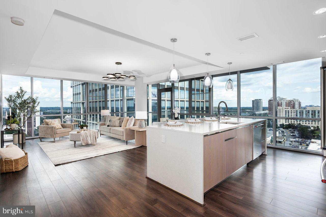 OPEN HOUSE SUNDAY 9/14, 1-3PM!
EXPERIENCE LUXURY URBAN LIVING AT ITS FINEST IN THIS BREATHTAKING CORNER UNIT !
Perched high above the Hilton Canopy Hotel in the dynamic and vibrant Pike & Rose community, this modern 2018-built CORNER UNIT is in " like new " condition, having been impeccably maintained by the original owners. Â It offers unparalleled panoramic views that will take your breath away. Enjoy sweeping east and south-facing views from the 16th floor, where stunning sunrises and the dynamic energy of the city unfold just outside your windows. Start each day with a spectacular sunrise, and enjoy the warm southern exposure year-round, with glimpses of the iconic DC skyline. On clear days, you can even spot the Washington Monument in the distance.
Just blocks from The Aquatic Recreation Center, Wall Park, and bike trails, this 1,452 square foot, 2-bedroom, 2-bathroom, 1-parking space condo is a true gem. Featuring soaring 9- and 10-foot ceilings and floor-to-ceiling windows throughout, this unit offers an expansive, open layout that creates a sense of space and sophistication. Designer-curated custom light fixtures enhance the home’s contemporary flair, with ceiling lighting fixtures and wall treatments professionally designed by Jenna Steckler Interiors.
Step into the sun-drenched living room, further illuminated by a stunning nine-light LED ring dimmable chandelier, floating like a cloud above the expansive open living area. The Euro-style kitchen is a chef’s dream, with Italian cabinetry, an oversized quartz island that comfortably seats four, and top-of-the-line Kitchenaid stainless steel appliances. Solid panel doors, engineered wood floors, contemporary hardware, and deluxe custom roller shades complement the clean, polished design. Additionally, this unit features a large balcony, perfect for relaxing or entertaining.
Framed by a wall of floor-to-ceiling windows, the spacious primary suite  features a striking wall mural of designer deep emerald cranes in flight, evoking a sense of serenity for a restful retreat. A generous walk-in closet with custom built-ins, and a custom remote controlled ceiling fan with a dimmable LED light, provide comfort and convenience.  Unwind in the luxurious owner's bath with an oversized frameless glass shower, dual sinks with quartz vanity tops, illuminated LED mirrors, and a separate water closet.   An additional second bedroom also faces south, offering flexibility as a guest bedroom or home office.  A second full hall bath  with a tub and  laundry with full-size washer and dryer round out this unit.
Just steps from the vibrant energy of Pike & Rose, this condo provides the perfect balance of tranquility and convenience. Residents of 930 Rose enjoy exceptional amenities, including a secure resident’s garage, concierge services, and private elevators. The rooftop level features soaring floor-to-ceiling windows, a sleek fitness center, beautiful lounge with a fireplace ideal for private parties and meetings, a billiards room, and an outdoor terrace with gas grills and expansive 360 views.
Step outside the lobby to explore a wide range of dining options, high-end shops, retail stores, iPic movie theaters, and endless entertainment. Socialize over coffee and croissants at Sunday Morning Bakery, indulge in an ice cream at Baked Bear, an acai bowl from South Block, or enjoy a round of bowling at Pinstripes. With something for everyone, the Pike & Rose community is truly a vibrant hub for all ages. Conveniently located just minutes from Whole Foods, Giant, Strathmore Music Center, and the North Bethesda Metro Station (red line), this location offers unbeatable access to everything!