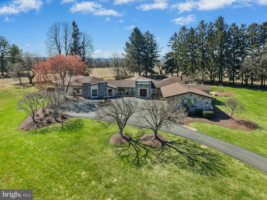 THE OASIS 
A private cul-de-sac is the setting for this extraordinary home offering single-floor living in the heart of the Lehigh Valley. The ultra-convenient location stands minutes from Cedar Crest Boulevard, Lehigh Country Club, Lehigh Valley Hospital and I-78.  

This remarkable contemporary residence was built in 1975 and sits on over 3 acres of mature landscaping and lush gardens. Open and airy living spaces are filled with natural light and designed for both comfortable living and elegant entertaining. Formal living and dining rooms are found in the front of the house, with a large family room and well appointed chef’s kitchen nearby. A sunny breakfast room, office/flex room, laundry room, and full bath complete this wing of the home. The primary suite is luxurious with plush carpet, a raised platform bed, and separate sitting areas. Dual baths and closets make this space both unique and practical. Also in this wing is a separate suite, and two hall bedrooms with built-in beds as well as an updated full bath. 

The piece de resistance is of course the indoor pool, a private retreat in the center of this incredible home. With walls of windows on all sides, the heated inground bromine pool has a retractable cover, vaulted ceiling with skylights, and access to both the interior of the house as well as the grounds beyond.