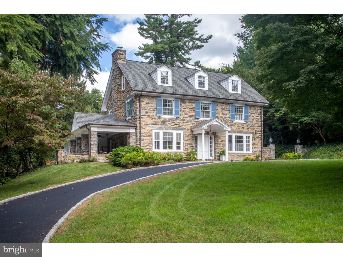 This enchanting stone Colonial with a covered entry, classic shutters & dormers, circular drive, pristine grounds & extensive private gardens enjoys incredible curb appeal in an idyllic neighborhood. While the house exudes traditional Main Line charm, the interior has been tastefully updated with renovations by Gardener Fox, creating abundant light & openness + beautiful, functional space for modern lifestyles. The fabulous flow with open rooms allows the families activities to be connected & affords easy entertaining. There are also cozy private places to escape to. The gracious center hall with rich wood floors opens through French doors at right to the dining room with elegant moldings & picture windows. To the left sits the living room centered by a brick wood-burning fireplace, with lovely moldings, built-ins & double French doors to the large covered patio. The kitchen & the Great Room room; the heart of the living space, were part of an extensive addition. The stunning kitchen is appointed w/custom cabinetry, granite counters & a huge island. The chef can go to town with a 6-burner Thermador range with double oven, built-in Sub Zero refrigerator, double dishwashers, built-in microwave & double sink with disposal. A wide opening exposes a sun-filled breakfast room. A capacious butler's pantry is great for serving guests. Gather around the stone fireplace flanked by built-ins in the vaulted Great Room & extend the party outdoors through triple French glass doors to the patio/yard & side covered patio. Main level conveniences are completed by a powder room + mudroom w/benches & cubbies. The highlight of the 2nd floor is the luxurious master suite with a tray ceiling bedroom, built-in TV area, dressing room/home office & spa bath with radiant heat floors, marble counters, soaking tub & frameless glass shower. There are 2 more sunny bedrooms & a full bath on this level. Two vaulted rooms, a full bath & unfinished attic occupy the 3rd floor. The walkout lower level is a great hangout space with a fireside rec room with TV and surround sound, gym, wine room, full bath & laundry rooms. WiFi security and thermostats, 3-zoned heat and AC, irrigation, plus recently replaced furnace , hot water heater and roof! The location is unbeatable, walkable to the top Baldwin or Shipley schools & the train station to Center City. Also close to the library, restaurants, Film Theater, coffee shops & weekly farmers market. All these amenities and yet still so delightfully quiet!