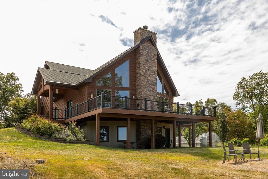 HIGH MOUNTAIN HOMESTEAD.....CUSTOM BUILT CEDAR CHALET ON 20 ACRES ELEVATED AT 1900 FT A TOP "LOCKINGER RIDGE" WITH STUNNING LONG RANGE MOUNTAIN VIEWS. THE HOME WAS DESIGNED TO SOAK IN THE VIEWS WITH A WALL OF WINDOWS IN THE GREAT ROOM. OTHER HOME FEATURES INCLUDE; OVER 3700 SQ FT OF LIVING SPACE, WOOD BURNING & GAS FIREPLACES, GOURMET KITCHEN WITH VIKING APPLIANCES, GRANITE TOPS EVERYWHERE, ACACIA WOOD FLOORS, HUGE MASTER SUITE AND NUMEROUS OTHER UPGRADES THROUGHOUT. THE POWER NEVER GOES OUT....GRID-TIED 11.75 kW SOLAR ARRAY WITH 4 TESLA BATTERIES STORES 54 kWh OF ELECTRICITY FOR YOUR PRIMARY BACK UP POWER. IF THE SUN DOESN'T SHINE, THERE'S A 22kW PROPANE GENERATOR TO RUN THE SHOW. STORAGE...STORAGE....AND MORE STORAGE....26X36 2 CAR GARAGE/WORKSHOP WITH 10X36 STORAGE ROOM ABOVE AND 11X11 ROOT CELLAR BELOW. 18X20 1 CAR POLE BARN/GARAGE, 12X22 CARPORT & 12X22 STORAGE SHED. HOMESTEAD ON TOP OF A MOUNTAIN? YES...YOU GOTTA SEE IT TO BELIEVE IT....MONSTER CHICKEN COOP, GREENHOUSES, GARDENS & ORCHARDS.....FRUITS & VEGGIES THAT ARE READY FOR HARVEST....PEACHES, APPLES, PLUMS, PEARS, APRICOTS, CHERRIES, GRAPES, CITRUS, BLUEBERRIES, ELDERBERRIES, RASPBERRIES, TOMATOES, ASPARAGUS, SQUASH, GARLIC, ONIONS, ETC. AN INCREDIBLE BOUNTY PRODUCED ON ABOUT 1/2 AN ACRE. LOCATED IN THE PRESTIGIOUS 10,000 ACRE AIRBNB FRIENDLY GATED MOUNTAIN COMMUNITY OF ASHTON WOODS.....A COMFORTABLE 2-2.5 HOUR DRIVE FROM NORTHERN VA, 5 MINUTES FROM PRIVATE COMMUNITY ACCESS TO NATHANIEL MOUNTAIN WILDLIFE MANAGEMENT AREA(10,000 ACRES OF PUBLIC HUNTING & HIKING) 15 MINUTES FROM MULTIPLE PUBLIC ACCESS POINTS ON THE SOUTH BRANCH OF THE POTOMAC RIVER, 20 MINUTES FROM MOOREFIELD; WAL MART, THEATER, RESTAURANTS, GOLF COURSE.... 40 MINUTES FROM SKI RESORTS.....PLENTY OF FEATURES AND BENFITS! TACKLE ALL YOUR OUTDOOR PURSUITS FROM ONE CENTRAL LOCATION. THE OWNERS HAVE WAY OVER A MILLION DOLLARS INVESTED IN THIS HOME AND IF YOU WERE STARTING FROM SCRATCH, IT WOULD COST WAY OVER A MILLION TO REPLICATE. AN ABSOLUTE STEAL UNDER 800K! WHY WAIT 2 YEARS AND SPEND WAY OVER A MILLION BUCKS TO BUILD SOMETHING SIMILAR WHEN YOU CAN HAVE IT TODAY?