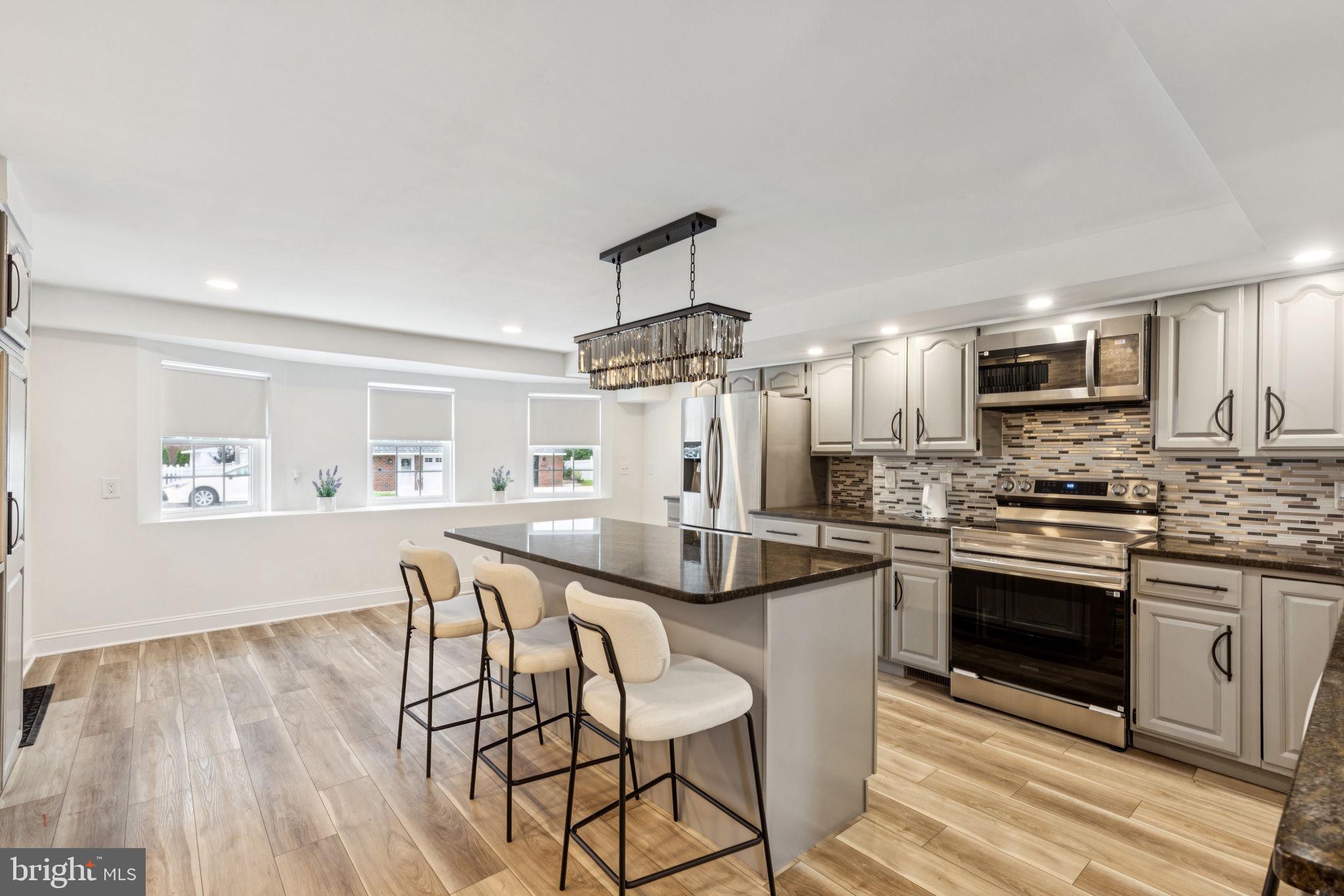 Welcome to this beautifully renovated 5-bedroom, 2.5-bath home now available in the highly desirable Somerton neighborhood of Northeast Philadelphia. With over 2,400 square feet of upgraded living space, this home offers a perfect blend of modern style, comfort, and functionality. Step inside to a stunning open-concept kitchen featuring gray cabinets, sleek dark green granite countertops, a spacious center island, custom backsplash, and Samsung stainless steel appliances. A dazzling crystal chandelier anchors the room, making it ideal for entertaining or everyday family living. The home features durable vinyl flooring, recessed lighting, and a neutral color scheme that suits any style. The second floor includes five bedrooms and two updated bathrooms, one of which features double vanities and a skylight for natural light. Downstairs offers a warm and inviting living area with a fireplace and direct access to the backyard. The outdoor space is just as impressive, with a freshly sodded lawn, a stamped concrete patio, and a fenced yard—perfect for relaxing, playing, or hosting guests. This move-in-ready home also includes a private entrance, new concrete driveway and walkways, modern exterior accents, and exceptional curb appeal. Don’t miss your opportunity to own this turn-key property in one of Philadelphia’s most sought-after neighborhoods. Schedule your showing today!