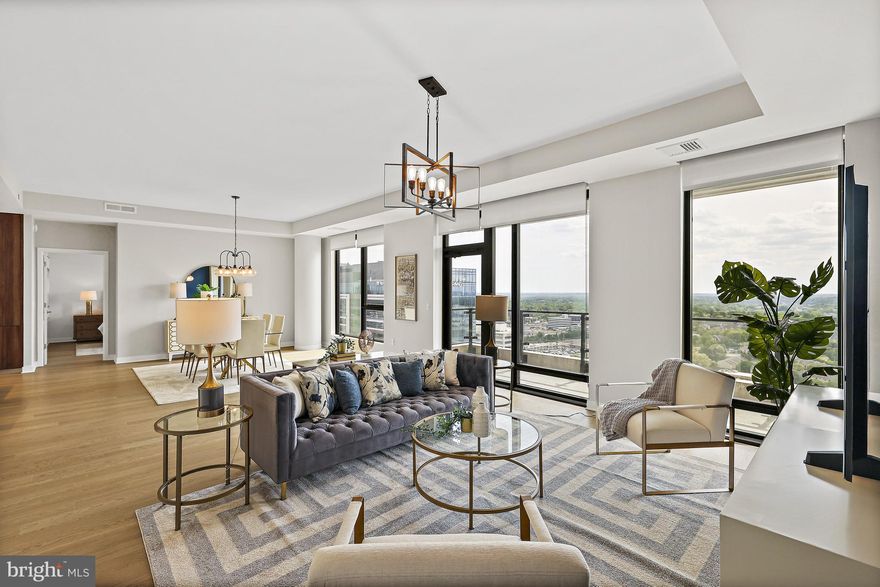 Located in the Verse at the Boro, Tysons’ most sought after full service residential building, this stunning 22nd Penthouse floor level residence with soaring ceilings exudes sophistication, ease, and delight throughout every space.   With 2 Bedrooms, 2 Full Bathrooms, one Half Bathroom, and a Den with a door and windows, 2206 is one of three residences in the building featuring this exceptional floorplan.  Stunning western sunset views illuminate the open main living area through floor-to-ceiling windows while the expansive wrap around balcony extends living space to the outdoors.  Gorgeous wide plank wood floors flow seamlessly throughout the spaces.  The modern and sleek Kitchen by Cecconi Simone features Italian cabinetry, quartz countertops and full height backsplash, oversized island with waterfall counter and seating for 4, Bosche appliances, and custom-built pantry closet and is open to the Dining and Family Rooms. The large and serene Primary Bedroom Suite has a dream walk-in closet with high-end custom-built cabinetry and multiple wardrobe mirrors, 2 additional walk-up closets, and a luxurious Bathroom with dual sink custom Italian vanities, porcelain tile, frameless glass shower with bench and niche, and separate water closet.  Bedroom 2 has an equally impressive closet with custom built-ins and an en suite Bathroom with tub.  A full size Laundry Room and Powder Room complete the main residence.  The property includes 2 parking spots in the secure garage and a separate storage unit.  The Verse offers 24 hour concierge, automated package retrieval, pet spa, state-of-the-art fitness studio, yoga room, guest suite, and massive sky park for entertaining, relaxing, or grilling out!   Modern restaurants, unique shops, the Icon Movie Theater, and the best Whole Foods on the east coast are right at your fingertips.  Close to the Greensboro Metro Stop.  The best that Tysons has to offer!