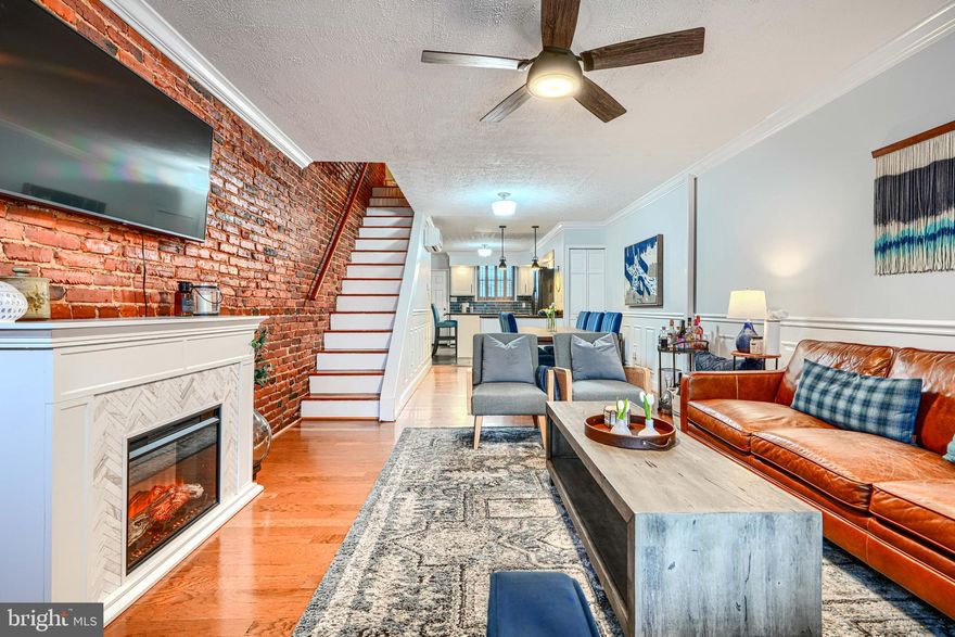 Welcome to 610 S East Avenue—a thoughtfully maintained extra wide, two-bedroom, one-bath rowhome located in the heart of Canton, just blocks from the park, local restaurants, and shops. Step inside to an open-concept main level featuring light colored hardwood floors, neutral paint color, exposed brick wall, crown molding, wainscoting, and plantation shutters, creating a high-end, custom feel. The front-to-back layout offers well-defined living and dining areas, flowing into an upgraded rear kitchen with granite countertops, modern white shaker cabinetry, stainless steel accents, a center island with seating for two. and pendant lighting over a bonus coffee/breakfast bar. From the kitchen, step outside to a private rear deck featuring a custom mural wall and gated yard with walk-down access—an ideal space for entertaining or enjoying a quiet morning coffee. Upstairs, you'll find two spacious bedrooms, one at each end of the home, featuring beautiful accent walls, ceiling fans, and ductless mini-split systems installed in 2023 for year-round comfort. Between the two bedrooms sits a tastefully renovated full bath with timeless tiled tub surround,  stainless steel fixtures and chair molding with vertical shiplap. The lower level offers unfinished space perfect area to finish off and make your own, currently used for extra storage with built-in shelving. To the rear, there’s a generous laundry area with utility sink, ideal workspace for an office setup, and walk-out access to the backyard. This home perfectly balances historic charm with modern updates and offers unbeatable walkability to all that Canton and Patterson Park have to offer. Schedule your showing today!