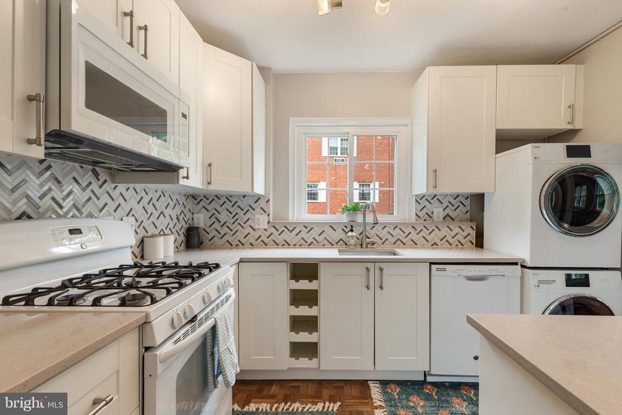 Beautiful one-bedroom Monroe model home in sought-after Parkfairfax! This light-filled home features a stairway leading up to an open floor plan with vinyl windows, hardwood flooring, & neutral paint throughout. The spacious living room is lined with large windows, allowing for tons of natural light to shine into the home. The kitchen is accented with updated white soft-close cabinetry, stone countertops, herringbone tile backsplash, & a newer stacked washer & dryer (2023). The separate dining area is accented with a ceiling fan with overhead lighting and overlooks the serene Parkfairfax grounds. The back hallway has a deep storage closet, as well as a linen closet, and leads to the incredibly spacious primary bedroom with a ceiling fan with overhead lighting & TWO closets. A full bathroom with new marble-inspired LVP flooring, a pedestal sink, a medicine cabinet mirror, & a sparkling white tiled shower completes this home. Parkfairfax amenities include 3 swimming pools, 2 volleyball courts, a basketball court, 7 tennis courts, an exercise facility, tot lots, a party room, a car wash/maintenance yard, laundry rooms, & walking trails! This home is in a PRIME location - close to I-395, the shops & restaurants of The Village at Shirlington, and just a short drive to Del Ray, Old Town, & DC!