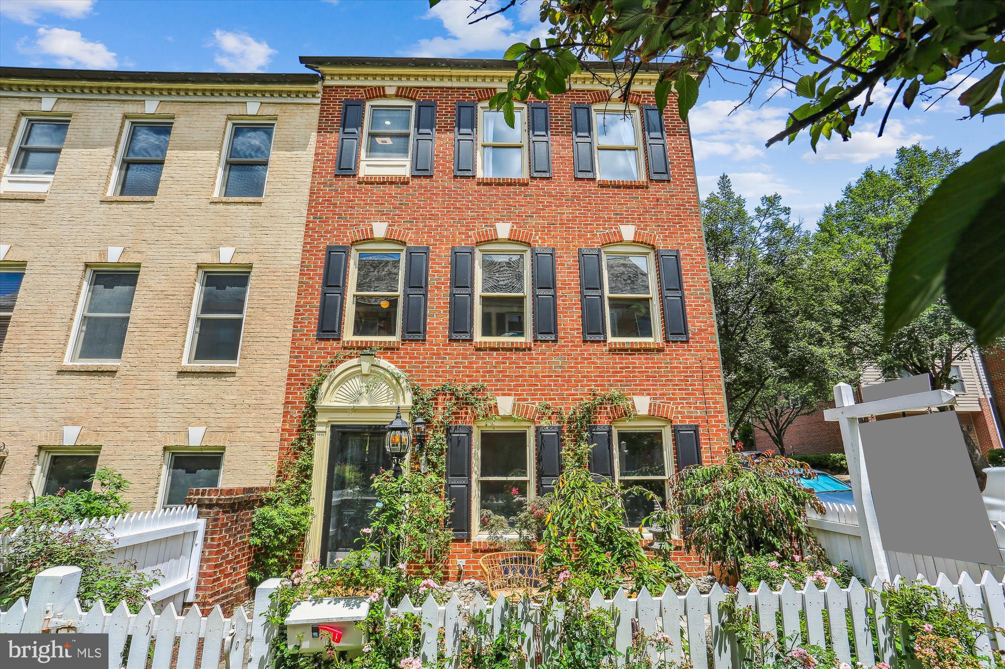 Beautifully updated end-unit townhome offering stylish renovations, sunlit living spaces, and fantastic outdoor areas. The lower-level entry courtyard welcomes you with a masonry patio, fully fenced and bordered by mature gardens—perfect for relaxing or entertaining. Inside, oversized porcelain tile flooring, custom built-ins, and designer lighting—including two statement chandeliers—create an inviting, modern feel. A custom-renovated full bath and convenient garage access complete this level. Upstairs, updated hickory hardwood floors flow throughout the expansive, open-concept main living area. The sun-drenched great room features recessed lighting, crown moldings, decorator light fixtures, and a three-sided gas fireplace. The adjacent dining area offers seamless connection to the living space—ideal for entertaining. The beautifully renovated kitchen is a chef’s delight with quartz countertops, stainless steel appliances, subway tile backsplash, decorator hardware, under-mount sink, and a triple window that fills the space with natural light. A five-burner gas stove and built-in microwave complete this exceptional culinary space. The adjacent laundry area provides added functionality with stacked stainless washer and dryer, countertop folding space, and a windowed pantry area. An updated powder room with modern flooring, lighting, and pedestal sink completes the main level. The upper level continues with hickory hardwood floors and includes three spacious bedrooms. The luxurious primary suite boasts vaulted ceilings, a lighted ceiling fan, abundant windows, and two closets including a walk-in. The fully renovated en-suite bath features custom tilework, dual stone vessel sinks, and a floating black walnut vanity with additional shelving—creating a spa-like retreat. The third bedroom features a double window, decorative niche, and closet. The second bedroom offers abundant natural light with two windows and a double-door closet. The hall bath showcases a terracotta-style floor, updated showerhead, and decorator lighting. Ideally located, this exceptional home offers comfort, style, and thoughtful updates throughout.