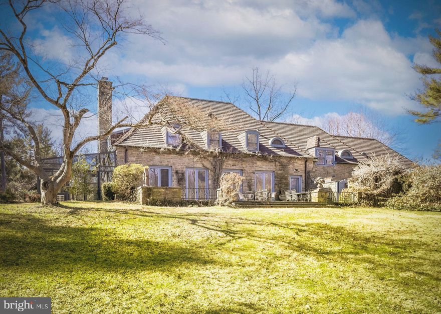 Welcome to 500 Telner Street, one of the finest Woodward houses in Chestnut Hill. Built in 1957, but resembling a 1925 house typical of the aesthetics of Chestnut Hill, this lovely estate was custom built for George Woodward, Jr. and his wife Harriet for their personal home. The Woodward family is well-known for building Chestnut Hill’s most charming estates. Its park-like setting and charming dovecote gracing the front entrance, surrounded by pink azaleas in Spring, make this fairy tale “cottage” come to life. This is one of the rare homes directly on Wissahickon Valley Park. Timeless charm, so typical in Woodward architecture, is brought to its zenith in this stone home, custom built to plans now archived at the Chestnut Hill Conservancy, with seemingly no expense spared. All the modern amenities you love, such as central air, a full 2 car garage, an attached separate apartment with its own private entrance, 5 full and 3 half baths (each bedroom and apartment with their own full bath), and enormous closets and attic space, offer comfort and convenience. With 8 inch deep granite window sills due to the thick walls, the house is exceptionally quiet due to the insulation, solid doors and stucco walls. Uniquely, the primary bedroom suite occupies an entire wing on the ground floor and features a spacious bath with dual bathrooms, each with its own shower or tub. The generous bedroom includes French doors opening to a private patio, a marble fireplace, built-in dresser, and separate closets, along with an adjoining sitting room with an additional marble fireplace. This wing creates total privacy from the other living spaces in the house. The grand living room, with an open floor plan connecting to the dining room, boasts 5 sets of French doors that are lit with morning sun, with an unobscured view filled with trees as it overlooks Cresheim Valley. Since 2013, multiple improvements have been made, including a new main kitchen with radiant floor heating, a Miele dish washer, Viking stove, convection oven, and a generous pantry complete with a cozy, sunny home office. The kitchen in the apartment is also new, with granite countertops, gas range and dishwasher, and added in 2020, a spacious southern exposure insulated glass addition opens out from the living room for your hot tub, 4 season relaxation and plant cultivation or display. A kitchenette is also located here. The circular and garage access driveways were repaved in 2023. The generous studio apartment has a separate entrance and contains multiple windows, a full bath and ample closets. The second floor contains 3 bedrooms and luxuriously, one full bath for each bedroom. Adding to the home's flexible layout is the possibility of complete separation of upstairs and downstairs due to the private entrance access to both the upstairs and the apartment. A large slate floor foyer at the front door absorbs all the comings and goings and stands the test of time. Located over the furnace room, the slate remains warm all winter long. A massive “playroom” in the finished basement, complete with fireplace, could be an exercise space, a guest bedroom (it has a large window), office, child or party space. While laundry is conveniently located on the ground floor, there is plumbing here in a large closet for another laundry facility. There is also a half bath in the basement and a very generous workshop space as well. An additional finished room which, at the owner’s option, could be reserved for the resident of the apartment to enlarge its capacity, or kept as part of the main residence.
