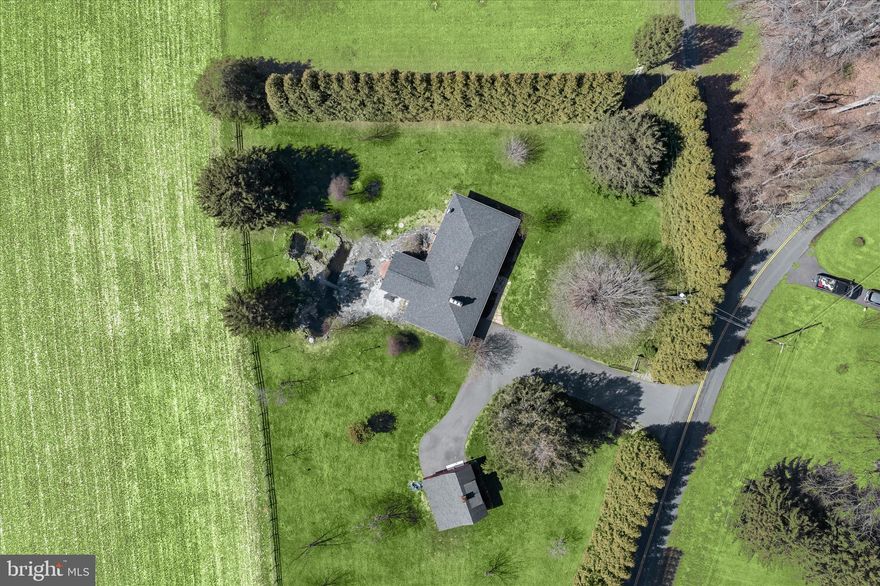 Surrounded by nature on 2.2 scenic acres with tranquil pasture views, this inviting 3BR, 2BA brick rancher with over 2,400 sq ft and a finished lower level offers a peaceful retreat with exceptional indoor and outdoor living. Beautiful hardscaping, a soothing waterfall koi pond, bluestone patio, and Amish-built barn create a truly picturesque setting. Inside, enjoy hardwood floors, updated baths, a stone surround wood-burning fireplace, and an updated eat-in kitchen with granite counters, stainless steel appliances, breakfast bar, and 42” cabinetry. The vaulted all-season sunroom is wrapped in windows showcasing panoramic views. Finished lower level includes rec room, fireplace, full bath, workshop area, and walk-up access. Convenient to APG, I-95, and local amenities.