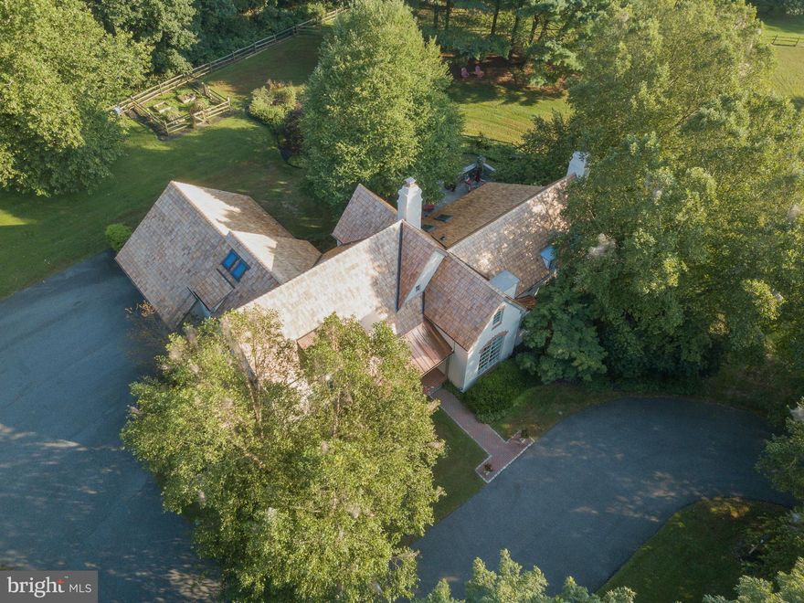 Welcome to this exquisite French chateau-style home nestled amidst preserved open space in Chadds Ford.  Designed by renowned architect, Jack Arnold, this custom home offers old-world charm combined with many modern amenities and updates.  As you pass through the stone gates you enter a serene retreat set on three acres preserved under an easement with the Brandywine Conservancy.  You will be charmed by the elegance of the home and the new cedar shake and copper roof (2020).  Entering the foyer notice the beautifully inlaid hardwood floors, archways and design details reflecting the custom renovation of the main living areas and kitchen in 2016.   To your right is the formal dining room that impresses with its beamed ceiling and stunning picture window.  Passing into the kitchen you'll appreciate the beautiful white cabinetry and mill work, quartz counters, farmhouse sink and stainless Bosch and Sub-Zero appliances.  The kitchen opens into the cathedral-style living room with exposed beams, built-in bookcases and gas fireplace.  Four arched French doors (2020) lead onto front and rear patios with peaceful views and manicured gardens.  Adjacent to the kitchen is a skylit breakfast room and a curved staircase leading to the guest suite.  From the breakfast room we enter the formal sitting room augmented with a stately Gothic-style stone fireplace (gas).  Returning to the foyer you pass through French doors to enter the master suite, which has a private garden patio, extensive walk-in closet and spa-like bathroom with soaking tub and plantation shutters.  The main level is completed with a renovated mudroom and laundry leading to the 2-car garage.  Upstairs enter two generous-sized bedrooms with hardwood floors joined by a renovated bathroom.  Off of one of the bedrooms is a large bonus room complete with built-in bookcases and a lovely reading window.  On the other side of the foyer is the fourth bedroom with en-suite full bathroom.  On the lower level is an expansive living area with a kitchenette accented with silk shantung wallpaper.  The lower level is completed with a fitness studio, yoga room/office and full bathroom.  Home features and recent updates include: 4 Zone HVAC with 3 main systems replaced in 2019, Freshly painted exterior (2020), Generac generator, whole house water filtration system, tankless Rinnai water heater, exterior LED lighting (2020), whole home entertainment system and new garage doors (2020).  A stucco inspection was completed in 2020, and the report is available for your reference.   This gracious home is an oasis and captures the spirit of why the Brandywine Valley is known as "Chateau Country."