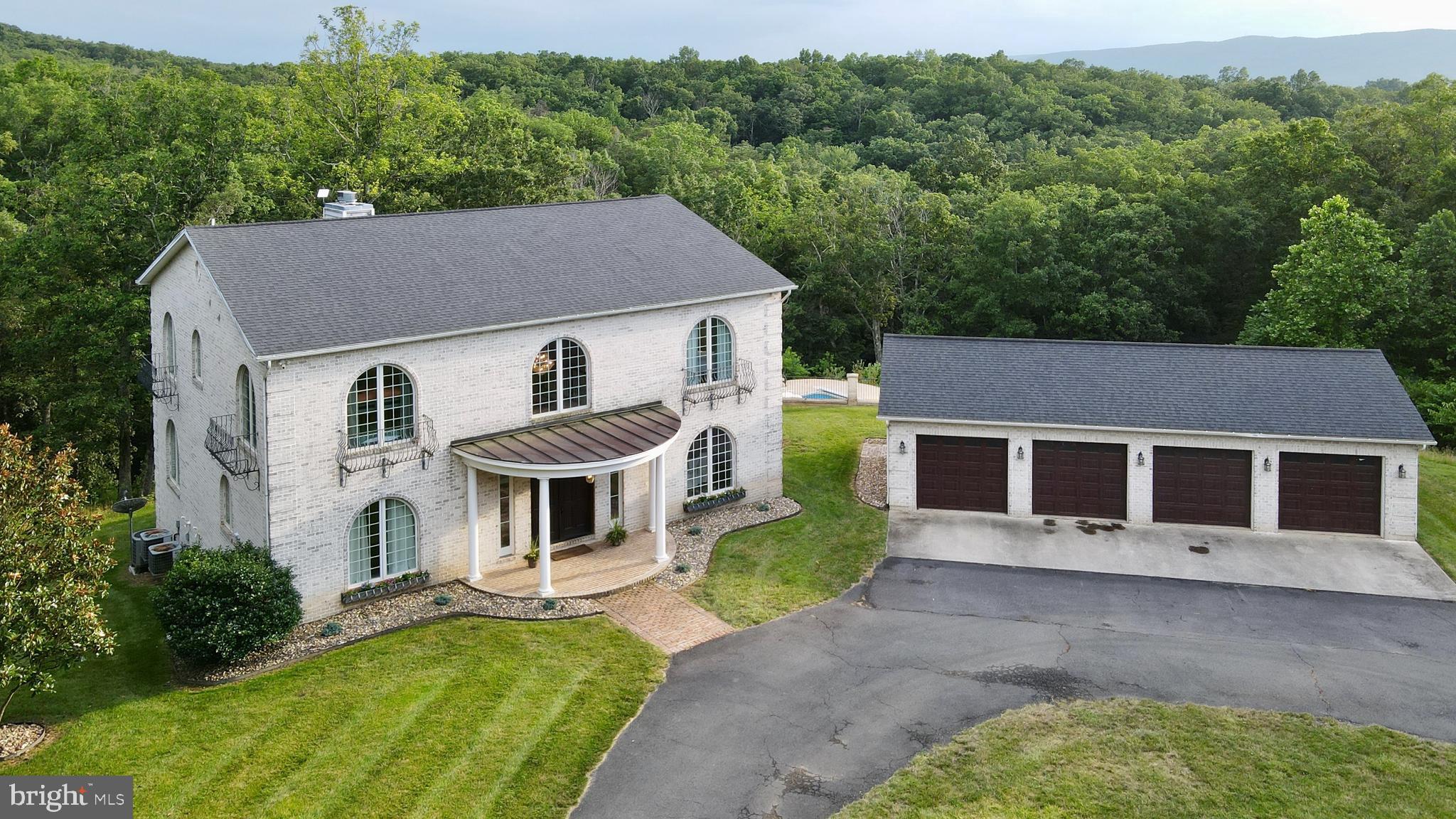 Welcome to 207 Westview Drive, a secluded sanctuary nestled on just over six wooded acres in the heart of the Shenandoah Valley—mere minutes from the charm of Historic Old Town Winchester. With over 6,600 square feet of beautifully finished living space, this one-of-a-kind property offers the perfect blend of luxury, comfort, and natural beauty. Tucked deep into the trees, yet close to shops, dining, and commuter routes, this is a home that feels worlds away—yet close to everything.
The main level welcomes you with sun-filled spaces, refinished hardwood floors (2024), and a layout designed for both everyday living and elegant entertaining. At the heart of the home, the kitchen is a true chef’s dream—anchored by a commercial-grade GE Monogram range beneath a striking arched stone hearth. A quartz island installed in 2024, Sub-Zero fridge/freezer, stainless steel backsplash, and KraftMaid cabinetry complete the space. A formal dining room sits just off the kitchen, while the expansive family room opens through double French doors to the rear deck and wooded views beyond. The main-level primary suite is a private retreat with a double-sided fireplace, walk-in closet with its own gas washer and dryer, and a spa-inspired bath with dual vanities, a jetted soaking tub, and separate tiled shower. A stylishly remodeled powder room rounds out this level.
Upstairs, four bedrooms and two full baths provide flexibility and space. The upper-level primary suite mirrors the main-level retreat with another double-sided fireplace and en suite bath. A connecting bedroom makes an ideal nursery or sitting room. Down the hall, two additional bedrooms share a beautifully updated full bath featuring a charming clawfoot tub and separate shower. A second laundry area with gas washer and dryer offers added everyday convenience.
The lower level is built for entertainment and extended living, featuring two well-sized bedrooms and a full bath with a beautifully tiled rain shower. A large movie theater room, game room, and stylish bar create the perfect setup for gatherings and relaxation, while upgraded systems throughout the home—including copper plumbing, three-zone HVAC, and LED lighting—enhance comfort and efficiency.
Outside, a sparkling in-ground pool invites summer fun with full-width steps, LED lighting, an auto-cover, and plumbing in place for future heating. The expansive deck, stone patio, and firepit offer inviting outdoor spaces to relax beneath the trees. A buried 1,000-gallon propane tank (owned and conveys) fuels both the pool and the whole-house generator with automatic transfer switch, while a commercial 80-gallon water heater fed by a Rinnai tankless system ensures reliable hot water.
A detached four-car garage is ready for hobbies or serious work—with 220V outlets wired in each bay, bright LED lighting, and plenty of space for tools and storage. The roof was replaced in 2019, rounding out the home’s thoughtful upgrades.
Private, peaceful, and just minutes from I-81, Route 7, Route 50, and an easy drive to Dulles International Airport—207 Westview Drive is more than a home. It’s your own piece of the Valley to retreat, recharge, and truly live.