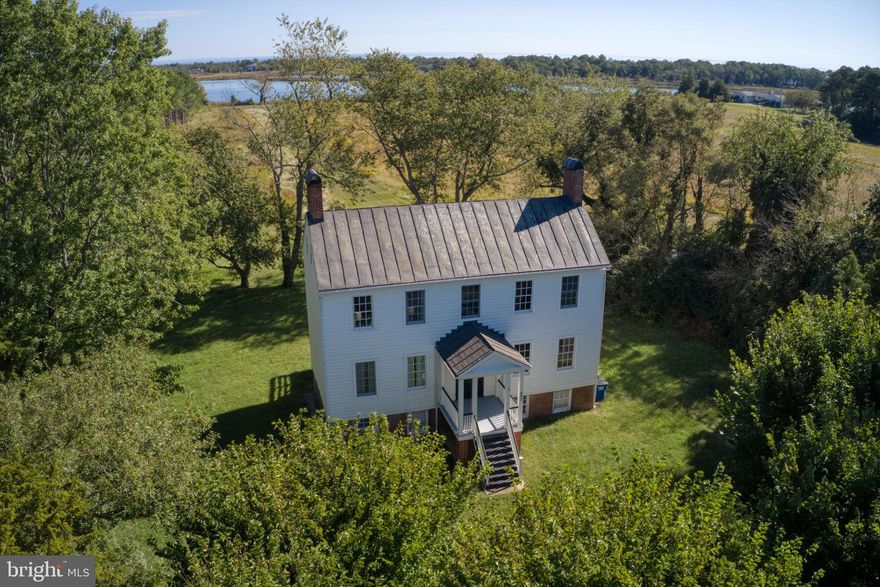 Here is your opportunity to own a tranquil waterfront retreat with 110 feet of shoreline! This gorgeous Center Hall Greek Revival (circa 1804) sits on 3.49 acres and blends period character with thoughtful modern updates. Rock Hall’s classic 2-over-2 architecture has been meticulously restored, offering gracious proportions, timeless millwork, a charming tin roof and natural light from every side!  The home's freshly renovated kitchen has new appliances, granite countertops and 10-foot ceilings. The charming built-in bookcases, two fireplaces, preserved wide-plank loblolly pine floors and  tin roof add to the charm and historic feel of this very special home.  HVAC new in 2025.  This home's coveted location is literal steps from Smith Point Marina, and the deeded boat slip on Rock Hole Cove provides direct water access for your boat or kayak.  Historic charm meets modern convenience across a serene, usable landscape—an exceptional setting for outdoor enjoyment and effortless entertaining.  A rare chance to acquire a historic waterfront property with both lifestyle and investment potential.