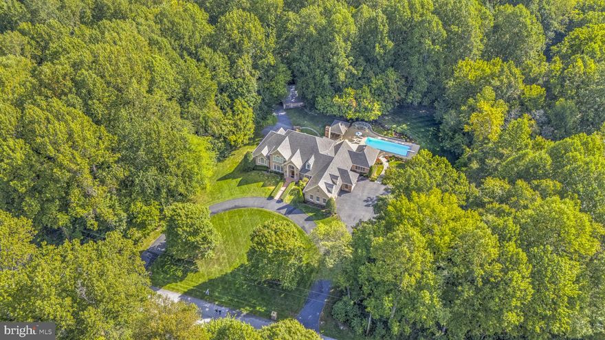 Welcome to your private oasis on a serene 3.4-acre cul-de-sac in highly sought-after Northern Calvert County. Custom-designed and built by a premier builder for his own family, this extraordinary all-brick residence masterfully blends luxury, functionality, and comfort. Every detail has been thoughtfully considered, from the first-floor primary suite with vaulted ceilings and custom built-ins to the seamless indoor-outdoor flow that makes entertaining effortless and enjoyable.

This stunning home presents like a showcase model, with numerous recent upgrades completed within the last few years, including a brand-new roof (2025), a 4-zone Carrier HVAC system with digital thermostats (2024), a Bosch dishwasher (2024), a synthetic shaker roof on the detached garage (2024), an upgraded alarm system (2023), and durable epoxy floors in the garages (2022). These improvements enhance both modern living and long-term value.

The thoughtfully designed layout creates a natural connection between the expansive gourmet kitchen, sunroom, and resort-style outdoor spaces. Step outside to enjoy a 44' x 18' Gunite pool with automatic safety cover, a 6-person hot tub, expansive brick patios, and a fully equipped pool house complete with a kitchen, full bath, TV, and surround sound, perfect for gatherings of any size.

A true standout feature is the extensive heated garage space: over 2,200 square feet across seven bays, accommodating up to nine vehicles, plus room for a workshop, studio, or hobby area. The detached 2-bay garage offers 13' of additional door clearance for RV or boat storage.

Crafted with enduring quality and refined finishes, including extensive custom millwork, hardwood and imported tile flooring, and commercial-grade mechanicals, this one-of-a-kind home offers a level of craftsmanship rarely found in the area. It truly serves as a private sanctuary for those who appreciate excellence in both form and function.

Just minutes from the Chesapeake Bay, the property provides easy access to marinas, the scenic North Beach boardwalk, waterfront dining, and all the charm of Bay life. Enjoy peace and privacy in a quiet, no-thru-traffic neighborhood while benefiting from excellent commuter access via Routes 2, 4, and 260. Dunkirk offers convenient proximity to Washington, D.C., Annapolis, and Northern Virginia, making daily travel straightforward without sacrificing the tranquility of rural living.