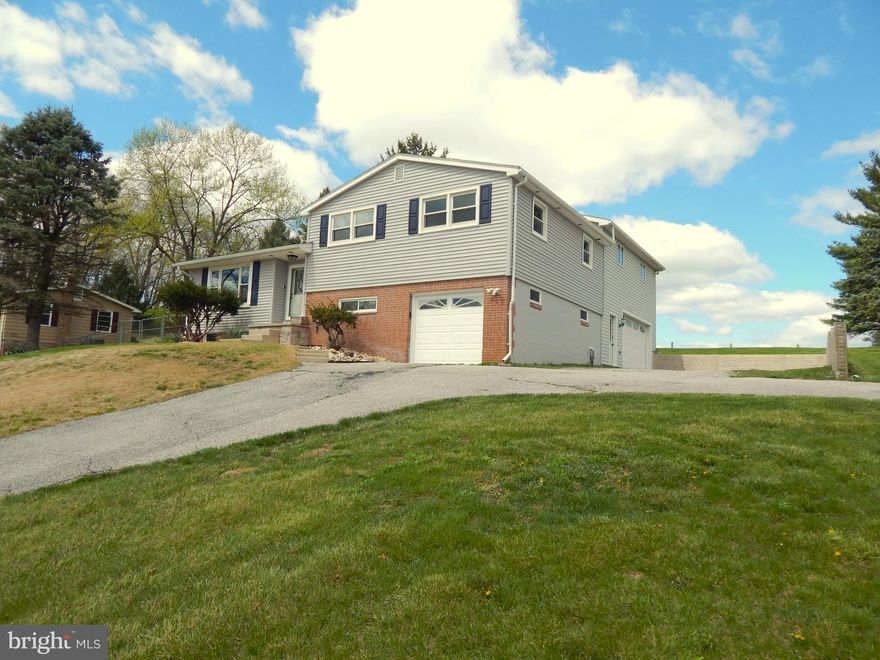 Beautiful split level home in West York Schools! 3 Bed, 2 Full bath, w/ 3 car garage, on .75 acre. A 28x24 addition was added to this home to give it a very spacious master bedroom with skylights, a master bath, and a private deck with a view.  It also added an oversized 2 car garage. Perfect to accommodate any hobbyist. Home  features a 21' x 13' sunroom, hardwood flooring, and new LVT flooring through-out. There is a walk-through room that connects to the master that could be used for many things including a 4th bedroom, a nursery, or even an office. There's also a finished room with garage entry to be used for whatever fits your needs. Plenty of storage in the unfinished basement. Home is minutes away from UPMC, the new Wawa, around the corner from BAE,  and is an easy commute to Rt 30. This one's definitely worth seeing!