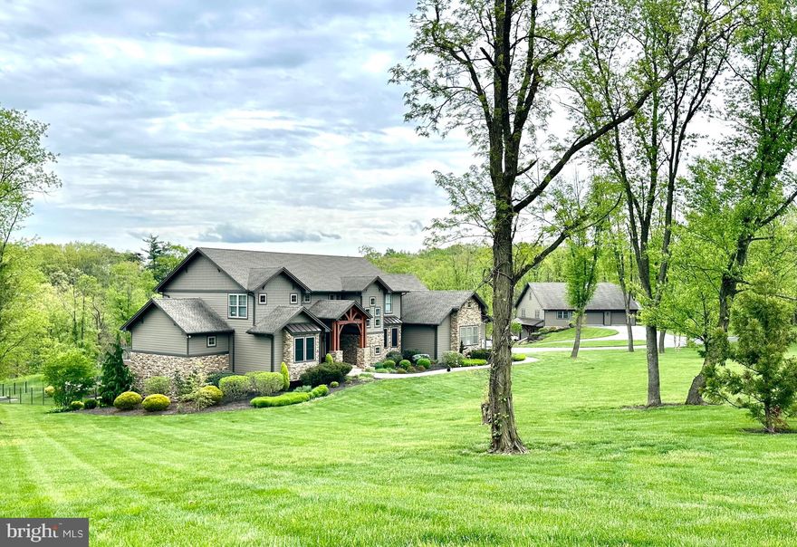 This one of a kind, custom home is nestled on a sprawling 19+ acres.  You are welcomed by a grand wood-framed entryway that sets the tone for the exceptional features found throughout this remarkable property.  The home's warm, organic aesthetic perfectly complements the breathtaking backdrop of the rolling hills and mature trees.  Expansive rear windows invited the outdoors in, allowing you to appreciate the beauty of the landscape and soak up the serenity of nature in every season. Open main-level living with soaring ceilings features a separate dining and living space along with spacious first-floor primary suite complete with a luxurious en-suite bath and large walk in closet, along with a beautifully designed custom kitchen that serves as the heart of the home.  Conveniently located on the main floor is your first of 2 laundry spaces, a nice office tucked away from the main living space and a large half bath.  Step out from your dining space, through the sliding doors and you'll find the showpiece of the home.  A grand, back deck made for relaxation and entertaining. With a dramatic covered section and cozy gas fire pit, it's the ideal place to take in the views, and enjoy the peacefulness of the property.  Ascend up the beautiful staircase to a large open area perfect for so many activities- this would be a great TV space for the kids, a crafting area; add desks and bean bags for a spot to chill and do homework or read a good book.  The 2 bedrooms both have their own en-suite baths and walk in closets with floating organizers.  The large room on the other side of the home is ideal for your 3rd upstairs bedroom.  Also a bonus, your 2nd laundry area is up here as well making it oh so convenient for everyone in the house!  Let's descend to the lower level, which is the true gem of the home.  Just a stove shy of having a full kitchen, you'll enjoy being belly up to the bar- which is a stunning granite countertop- and enjoy those moments with family and friends down here.  A full size refrigerator, dishwasher, microwave, stunning custom cabinets, pantry and so much storage.  The high ceilings make this space feel so open and inviting.  A large room off to the side can be used for whatever you desire.  Home gym, another bedroom, office- the possibilities are limitless.  A lovely guest bedroom, full bath and tons of storage complete the rooms in the basement.  Walkout to your own piece of paradise that is the paver patio.  With a built in fire pit, outdoor kitchen, mounted tv- all you have to do is add the hot tub to complete the package.   A large workshop/outbuilding gives room for all of your hobbies, with a finished lower level garage, built in air compressor and pressure washer.  There is nothing these owners didn't think of.  No expense was spared and everything was completed meticulously with lots of thought and love.  A barn with stables and pasture complete the other side of the property along with a small chicken coop and greenhouse.  This is every nature lovers dream.  A true staycation, that you'll never want to leave!