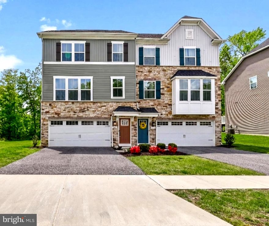 End-of-row privacy. Designer finishes. Move-in ready. Model-like presentation.

This exceptional stone-front semi-detached home in Quiet Waters at Norman Creek offers three finished levels of refined living.

Arrive to an oversized parking pad and attached two car garage. The entry level features a spacious family room, half bath, storage, and walk out access to a private rear yard.

The sun-drenched main level features an open concept layout with high ceilings, luxury flooring, recessed lighting, and crown molding. The living and dining areas flow into a designer kitchen featuring a stunning "12-foot quartz island" stainless steel appliances, custom backsplash, deep stainless steel undermount sink, and a pantry closet. Step out to the balcony overlooking green space and a serene, private, tree - lined setting.

Upstairs offers two secondary bedrooms, a full bath, and second-floor laundry. The expansive primary suite includes tray ceilings, a large walk-in closet, and a spa-style bath with dual vanities and an oversized walk-in shower with built-in seating.

Located near shopping, restaurants, nightlife, and major commuter routes, this home is positioned at the end of the community offering a setting that feels private and exclusive.