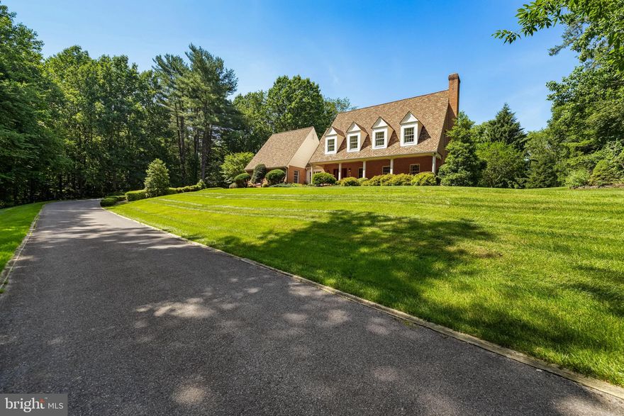Charming Nantucket-style brick Cape Cod tucked away on 10.5 private acres at the end of a quiet drive. Surrounded by nature, the traditional floor plan features spacious gathering areas perfect for entertaining—formal living and dining rooms, a cozy family room with fireplace, a first-floor office, and a sunroom with three walls of windows and a brick floor leading to a serene outdoor patio. The kitchen offers a breakfast area and walk-in pantry. Upstairs, the primary suite includes a sitting area and wood-burning fireplace, plus three additional bedrooms. Enjoy a classic front porch, freshly painted interiors with neutral tones, crown molding, and hardwood floors throughout. Oversized 2-car garage plus a barn ideal for vehicles, equipment, or storage. Unfinished basement offers endless possibilities. Very well maintained with many recent updates.