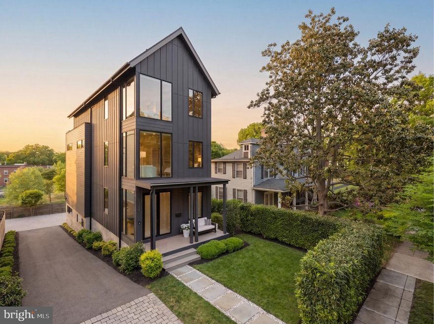 Ideally positioned along Hardy Park in the Palisades and directly bordering Georgetown, 1522 Foxhall Road NW offers a rare blend of contemporary architecture, privacy, cutting-edge craftsmanship, and direct connection to nature and retreat. Hidden behind tall perimeter hedges, the residence opens to light-filled interiors with 9-foot ceilings, where walls of glass and a retractable NanaWall dissolve the boundary between indoors and the landscape.

From the moment of entry, the home is oriented toward the outdoors. The formal foyer frames views through the rear living spaces to bamboo and gardens beyond, establishing an immediate sense of tranquility and retreat rarely found within the city. Wide-plank flooring, custom Portola Paint finishes, recessed architectural lighting, and clean contemporary lines establish an understated sophistication throughout.

Designed for both everyday family living and large-scale entertaining, the main level connects the kitchen, dining, living, and outdoor spaces in a highly functional layout. Floor-to-ceiling glass surrounds the dining area and family room, while the NanaWall opens fully to the rear terrace and Hardy Park, allowing gatherings to extend naturally outdoors. The relationship between the interior spaces and the surrounding greenery creates an atmosphere that feels calm, open, and distinctly removed from urban Washington despite being just minutes from Georgetown. Recent updates include refreshed second-floor and primary baths, along with a newly installed gas fireplace in the main living area. The home is also ideally situated just down the street from neighborhood favorite Jetties, with tennis courts and a playground located just below, adding rare everyday convenience and access to recreation just steps away.

Centered around a Blackstone waterfall island with an integrated Bosch cooktop, the kitchen balances strong visual design with functionality. Extensive custom cabinetry, paneled Bosch refrigeration, integrated appliances, and a walk-in pantry provide substantial storage while maintaining a streamlined aesthetic. From both the kitchen and living areas, views extend directly into the surrounding landscape and beyond.

Three bedrooms occupy the second level, including a secondary primary suite set within the tree canopy with exposures on three sides. The suite includes a custom walk-in closet and a bath finished with RH vanities, Porcelanosa tile, double sinks, and a glass-enclosed shower. Additional bedrooms feature oversized windows overlooking the quiet streetscape of the Palisades, offering flexibility for family living, guest accommodations, or workspace needs.

The top level is devoted almost entirely to the primary suite. Cathedral ceilings and multiple skylights shift light throughout the day, while a secluded balcony captures unobstructed views over parkland and evening sunsets across the treetops. A boutique-style dressing room with extensive built-ins and a central island connects to the primary bath, which includes a freestanding soaking tub, a skylit walk-in shower with dual shower heads, RH vanities, Porcelanosa tile, and a separate water closet. An additional flexible room on this level is well suited for a sitting room, office, or fitness studio.

The fully walkout lower level continues the home’s entertaining focus with a spacious recreation lounge, custom wet bar, wine storage, guest bedroom, full bath, and a dedicated mudroom and laundry area with an integrated dog-washing station. Direct access to the rear patio further extends the indoor-outdoor living experience and connection to the surrounding natural setting.

Set within one of Washington’s most established residential neighborhoods, with direct access to trails, top-rated schools, and Georgetown, 1522 Foxhall Road NW offers a distinctly modern living experience defined by privacy, tranquility, natural surroundings, and the rare feeling of escape within the city.