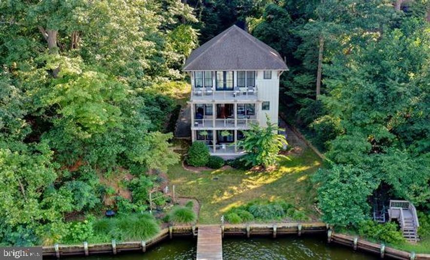 Sophisticated waterfront home designed by award-winning ABS Architects, beautifully captures the panoramic views of the Severn River.  Located just minutes from everything the Annapolis area has to offer this fabulous home is nestled amongst mature trees creating a private oasis that feels like you are worlds away from it all!  The high level design and thoughtful finishes can be seen in every detail of the home.  The soaring ceiling height, walls of windows and outdoor space on every level creates a seamless connection to the surrounding nature and the water.  The immediate water views as you enter into the spacious foyer, draws you into the home and to the entry level ensuite bedroom with covered patio and out to the lush backyard to the water's edge.  Upstairs offers an open floor plan with gourmet Kitchen, Living room with stone fireplace, dining room and waterside balcony all taking full advantage of the unobstructed water views.  Beyond the kitchen is a powder room and cleverly designed combination of laundry room, office, pantry and tons of storage. Not a single square foot is wasted, just like on a beautifully crafted ship. The upper level houses 2 ensuite bedrooms including the Primary bedroom suite with private balcony, custom walk-in closet and luxurious bath with walk-in shower.  Enjoy the ever changing scenery of boats and wildlife from the balcony or from bed as you drift off to sleep, every spot in the room has captivating views. Extending out 90' into the Severn River, the private pier with multiple slips is a boating enthusiasts dream and offers easy access to downtown Annapolis, the Chesapeake Bay and beyond. Welcome Home!