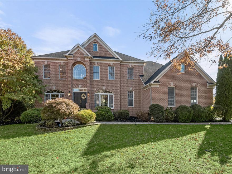 Welcome to this stunning brick colonial home located on a desirable corner lot in the prestigious Turf Valley Vistas community. Spanning an impressive 6,501 square feet across three well-appointed levels, this residence combines elegance and functionality with a beautiful color palette, hardwood flooring, and high-end finishes throughout. As you approach, a charming paver walkway surrounded by thoughtfully designed landscaping leads you to a grand two-story foyer, where the home welcomes you with open arms. Flanking the foyer are the formal living and dining rooms, each adorned with crown molding and with exquisite Palladian windows that allow natural light to flood the spaces. The heart of the home is the breathtaking family room, which features a soaring two-story ceiling and another magnificent floor-to-ceiling Palladian window, complete with a cozy fireplace, perfect for those chilly evenings. This space flows seamlessly into the gourmet kitchen, designed for both functionality and style. Here, you’ll find 42-inch cabinetry with convenient roll-out shelves and elegant undermount lighting, complemented by exotic granite countertops and a large island. High-end appliances, including a SubZero refrigerator, Elica cooktop, and Jenn-Air wall ovens, make this kitchen a chef’s dream. A walk-in pantry adds to the kitchen’s appeal, while a breakfast area provides a lovely spot for casual meals. A sunroom off the breakfast room, fitted with custom plantation shutters, offers a delightful space to enjoy morning coffee or an afternoon read. The main level also boasts a versatile den with beautiful windows, another room serving as an ideal home office option, along with a laundry room and a powder room for guests. Two staircases provide convenient access to the upper level, where the primary suite awaits. This luxurious retreat features a cozy sitting room and two expansive walk-in closets. The en-suite bath is nothing short of spectacular, showcasing two vanities with granite counters, a sumptuous soaking tub, and a floor-to-ceiling tiled shower with a frameless glass door. The upper level also includes a second bedroom with its own walk-in closet and private attached bath, while two additional bedrooms share a well-appointed bathroom featuring a double vanity. Venture down to the sprawling lower level, which is designed for both relaxation and entertainment. Luxury vinyl plank flooring flows throughout, highlighting a spacious recreation room with a second fireplace and kitchenette, perfect for hosting family gatherings or movie nights. Two bonus rooms offer flexibility for use as home offices, hobby spaces, exercise rooms, or media rooms. This level also features a fifth bedroom and full bath, making it a complete living area for guests or extended family. Storage rooms ensure that everything has its place in this thoughtfully designed home. Outside, the property features a composite deck that overlooks a serene backyard adorned with mature trees, creating an idyllic outdoor oasis for gatherings or quiet evenings under the stars. The side-loading two-car garage is equipped with a Tesla car charger, catering to modern living needs. As a resident of Turf Valley Vistas, you’ll be in close proximity to an array of exceptional amenities at the Turf Valley Resort, including a pool, tennis and pickleball courts, an indoor pool, a spa, a championship golf course, and a fitness center. This home offers not only luxury living but a lifestyle of leisure and recreation.