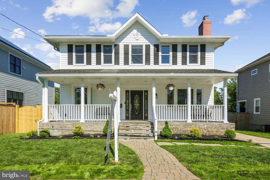 OPEN SATURDAY 12-3.  Storybook transformation into a bright and open 4BR/4.5BA three-level colonial with an old-fashioned front porch and off-street parking in Georgetown Village, just one block from the elementary school. Following expansions and renovations in 2022 and 2026, the home nearly doubled in size, now offering over 4,800 square feet of living space across three levels, including a lower-level in-law/au pair suite. Fine craftsmanship, unique design, and quality materials define this showpiece home, highlighted by an expansive kitchen/dining/great room; newly refinished hardwood flooring throughout the main and upper levels; fully renovated bathrooms with designer porcelain and ceramic tile; custom painting; upgraded and recessed lighting; new designer carpeting and LVP flooring on the lower level. Andersen windows, along with a newer roof and siding, add lasting value. The outdoor space is equally impressive, featuring professional landscaping with manicured beds, a newly fenced yard, a newly constructed TimberTech deck with wrought iron railings, and a private sunken patio with access to a storage room.  Cobblestone paver walkway and flagstone steps lead to the covered front porch with composite decking, beaded ceiling, vinyl railings, and recessed lighting.  Glass front door with side transoms opens into the foyer and living room, which features a wood-burning fireplace and a bay window. Flexible study or dining room with glass French doors opens to a hallway with a separate exterior side entrance and a corridor to the kitchen. The open-concept chef’s kitchen features self-closing white Shaker-style cabinetry with pull-out drawers, quartz countertops, a tumbled tile backsplash, a porcelain farmhouse sink with a box window ledge, champagne-bronze fixtures, upgraded appliances, a commercial-range hood, and ample pantry space. The center island with a quartz waterfall edge and cage lighting opens to the informal dining area and great room, featuring abundant windows, rear double French doors to the deck, a built-in linear electric fireplace, and custom bookshelves. Renovated powder room completes the main level.  Solid-wood staircase with a carpet runner leads upstairs to a hallway with a designer chandelier, recessed lighting, and a linen closet. The open loft area—ideal for a playroom, exercise space, or media room—features a glass sliding barn door to the laundry room. The primary suite offers recessed lighting, a ceiling fan, a separate sitting area with a linear electric fireplace, and a custom walk-in closet with built-ins. The renovated primary bath includes large-format porcelain tile flooring, a double vanity with a marble top, a separate water closet, and an oversized walk-in shower with a frameless glass enclosure. Two additional bedrooms with ceiling fans and recessed lighting, along with a remodeled hall bath featuring tile flooring, a granite vanity, and a porcelain-tile tub surround, finish the upper level.  The walk-out lower level includes a recreation room with new carpeting, built-in bookshelves, and a full bath. A step-down leads to the private in-law/au pair suite with its own glass-door side entrance, LVP flooring, second laundry hookup, bedroom with a walk-in closet, and a full porcelain-tile bath with a zero-entry, curbless shower. The suite’s full daylight living area includes recessed lighting, a linear electric fireplace, a full kitchen, and French doors opening to the sunken concrete patio with the deck above. A storage room is accessible from the patio. Three zones of heating and cooling (2018 and 2022), along with newer roof, siding, and gutters (2022), complete this exceptional offering.