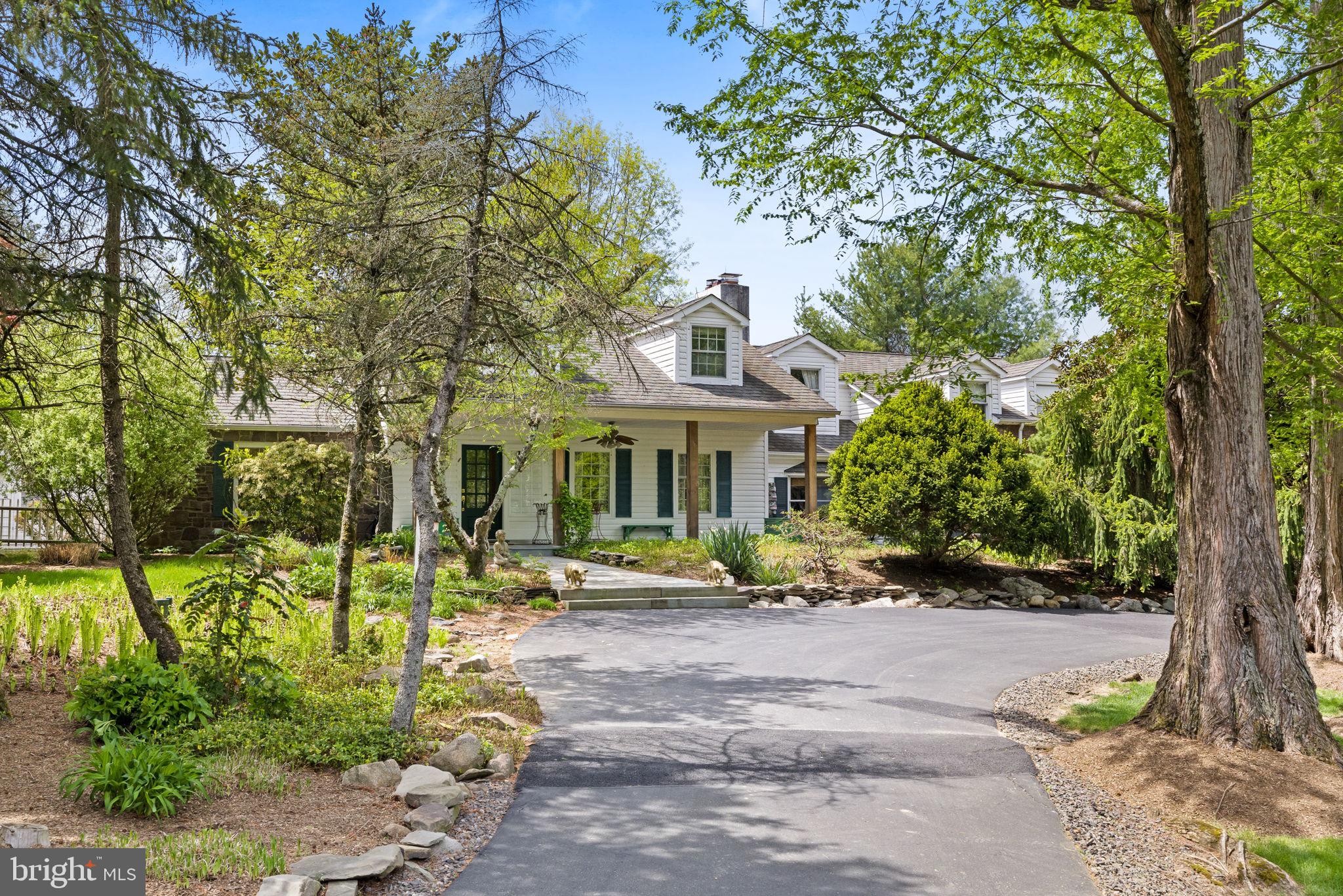 Located on one of the most picturesque, coveted roads in Solebury Township, that features a historic covered bridge, is an expanded Cape Cod residence. The home, which sits on 3 bucolic acres, is surrounded by lush mature landscaping, walking trails, and stone terraces. And don’t forget the pool and koi-filled pond! Elegantly refreshed and thoughtfully designed, the residence boasts architectural details and generous living spaces just minutes from downtown New Hope. From the moment you arrive, the expansive covered front porch sets the tone with its charming flagstone flooring that evokes the timeless beauty of a Southern veranda. Step inside to discover wood flooring, mostly throughout, custom wainscoting, four fireplaces and a breakfast room that is continually bathed in natural light. Most coveted is a first floor primary bedroom with a sumptuous en-suite bath that features a soaking tub and walk-in shower. The first floor plan continues with a formal dining room and living room that flank the entryway. Facing the spectacular lawn and gardens is a cozy sitting room which is adjacent to the breakfast room and gourmet kitchen, outfitted with top-tier Viking and Subzero appliances, a cooking island, wet bar with a copper sink and custom cabinetry. The eat-in breakfast room flows seamlessly into the adjoining spacious and airy sitting room . Also on the first floor is a "Ralph Lauren" library with fireplace, an over-sized half bath and a laundry room. A newer and separate wing offers a grand library, with custom built-in bookcases and a wood-burning fireplace. This wing has a separate staircase to a large Guest Suite with spacious bath. The main upper level offers 2 large bedrooms, and a hall bath. Also included is a two-car side entry attached garage.. This property offers both privacy and tranquility, all within the award winning New Hope-Solebury school district. An extraordinary opportunity to own a residence on one of the idyllic country roads in Solebury!
