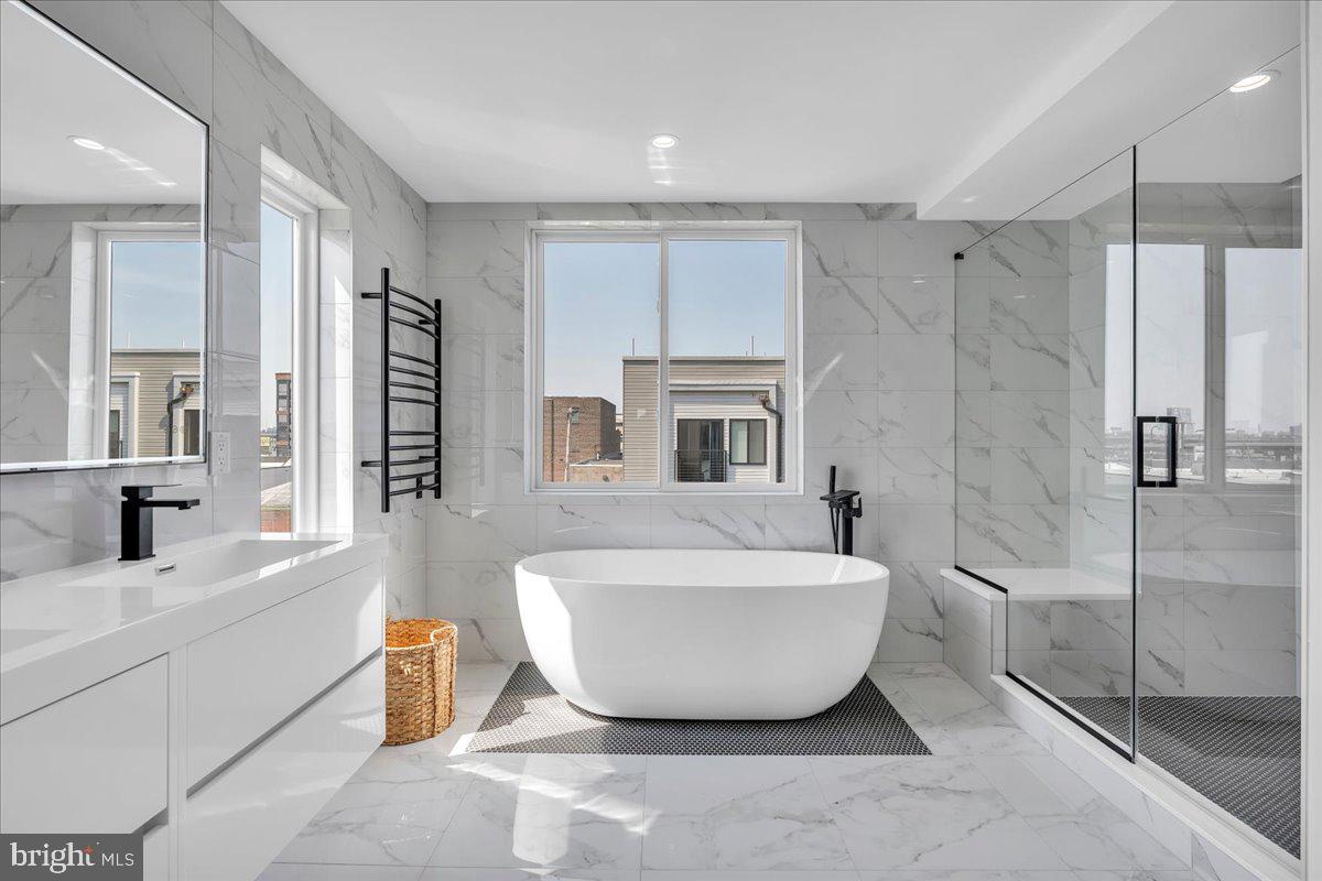 Last property available in this development! Welcome to 2620 E Hagert Street, a beautifully designed 3 bed, 3 bath townhome located in the vibrant Fishtown neighborhood. This modern corner unit offers sunlight drenched & thoughtfully crafted living space, combining clean, contemporary design with comfort and functionality —and it comes with the added benefit of a 10-year tax abatement, offering long-term savings for the new owner.
Step inside to discover an airy open layout featuring high ceilings, wide-plank hardwood floors, and oversized windows that flood the home with natural light. The main level features a stunning custom kitchen with quartz countertops, a large island, sleek cabinetry, and stainless steel appliances. While the kitchen and living room are separated by two levels, the design maintains an open, connected feel, giving each space a distinct identity without sacrificing flow—perfect for entertaining or relaxing. Upstairs, the luxurious primary suite offers a peaceful retreat with a walk-in closet and spa-like ensuite bathroom with a double vanity, floating tub, and glass-enclosed shower. Two additional bedrooms provide ample space for guests, home offices, or growing families. The fully finished basement adds even more versatility, perfect for a media room, fitness area, or creative workspace. One of the standout features of this home is the expansive rooftop deck, offering unobstructed views of the Philadelphia skyline and Ben Franklin Bridge—an ideal spot for entertaining.
An attached garage adds rare convenience in the city, providing secure parking and additional storage. Located on a quiet residential block just steps from the heart of Fishtown, this home offers easy access to neighborhood favorites like Reanimator Coffee, Green Eggs Café, Loco Pez, and the new Anna & Bel Hotel. With close proximity to I-95 and the L train, the location of 2618 E Hagert makes for an easy commute to anywhere in the city and surrounding areas. This is modern city living at its best—schedule your private tour today.